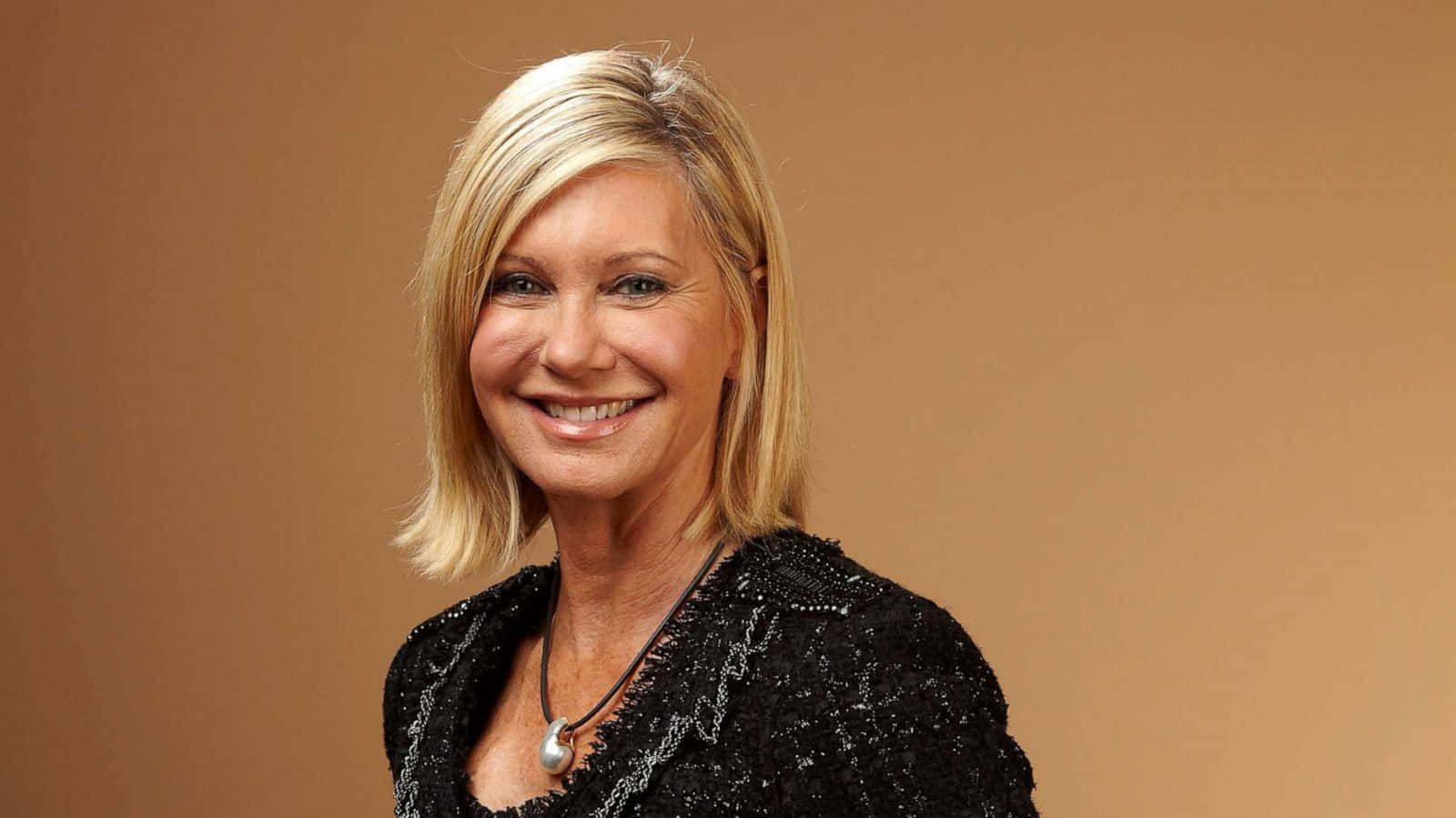 Olivia Newton John In Brown Backdrop Background