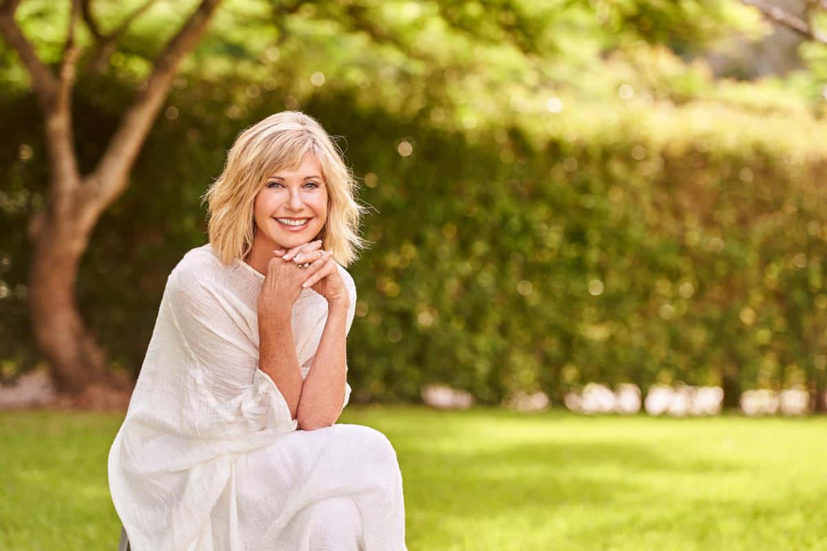 Olivia Newton-john Posing In A Stylish Outfit Background