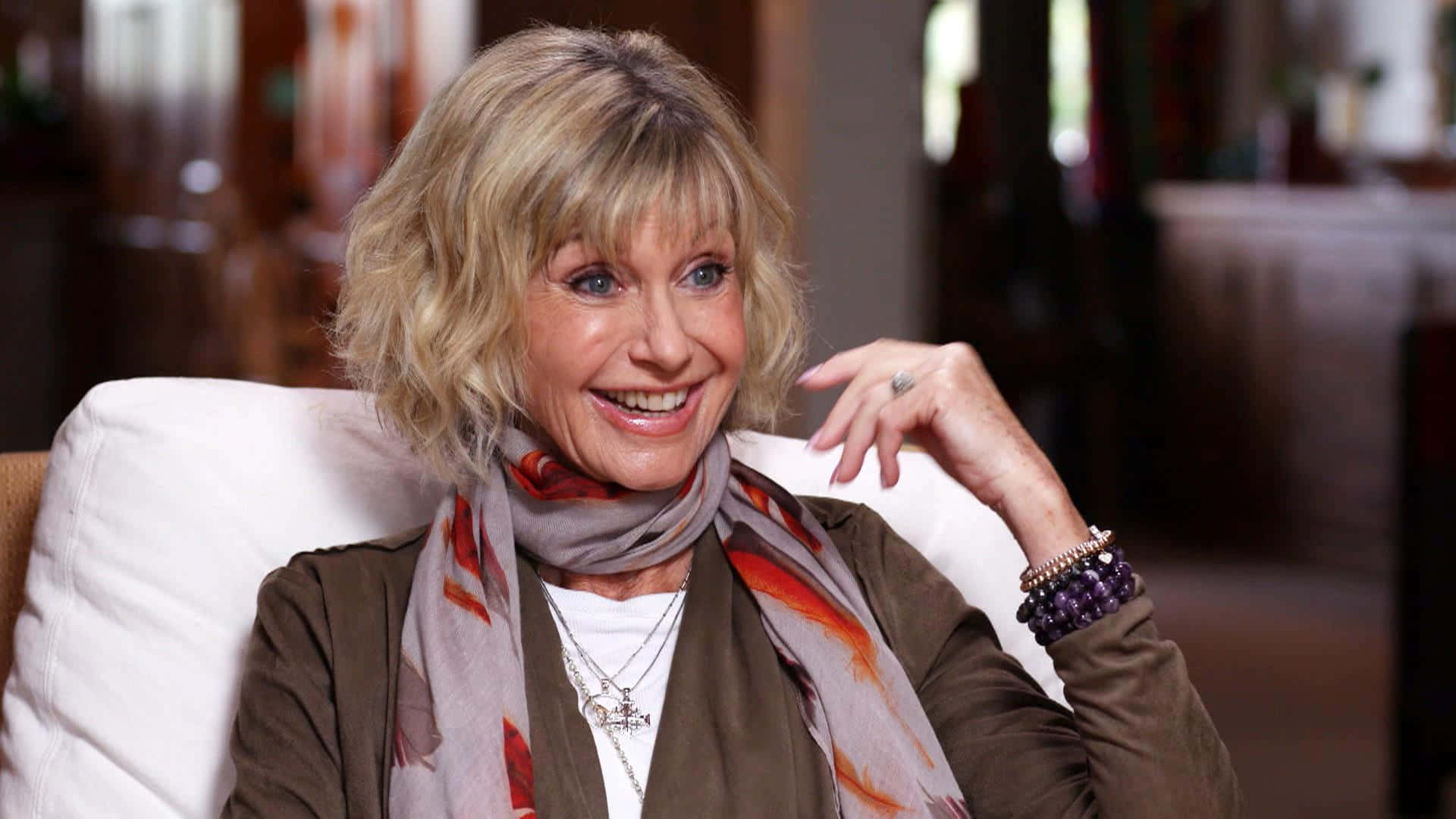 Olivia Newton John Smiling During Interview Background