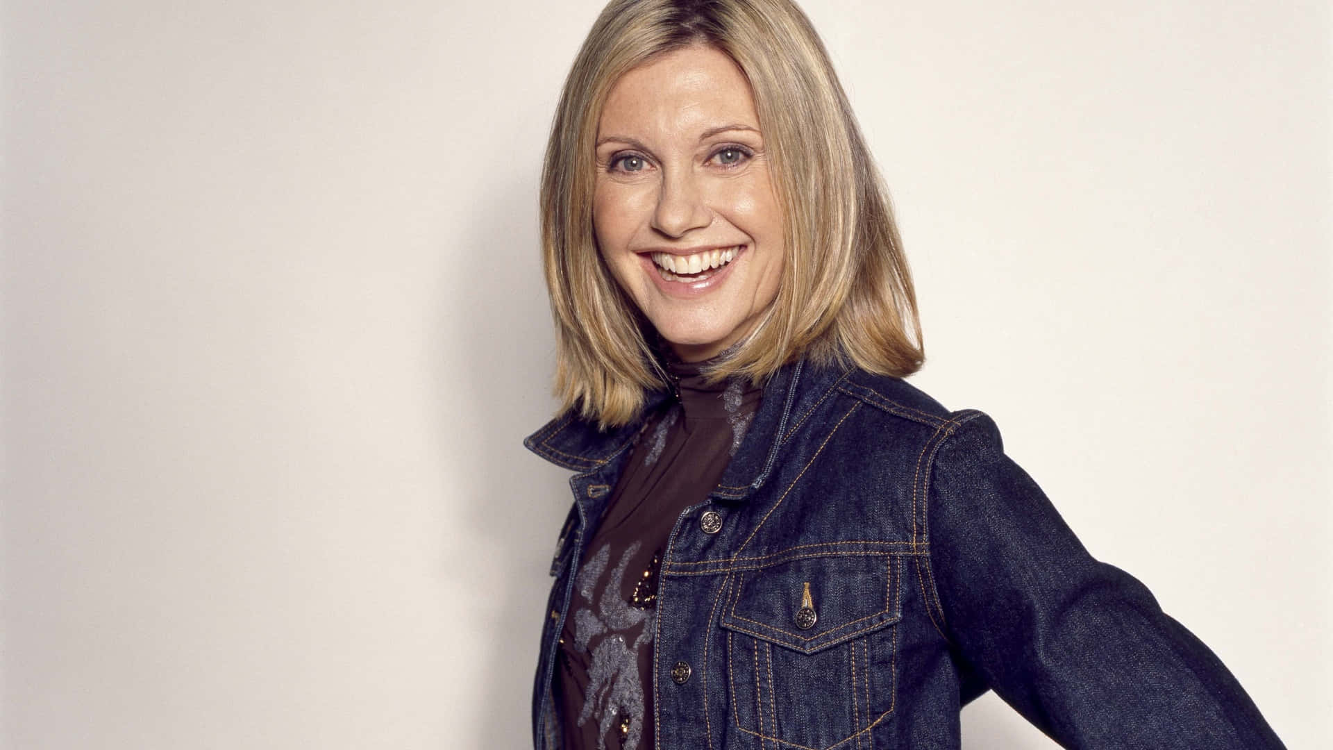 Olivia Newton John Wearing Denim Jacket Background