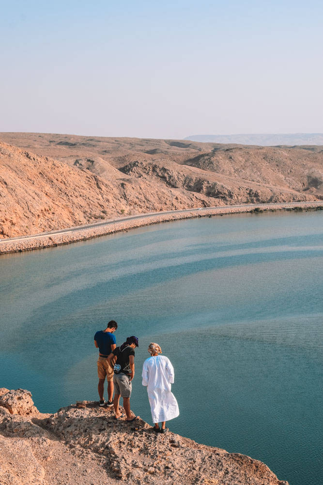 Oman Three Men On Cliff