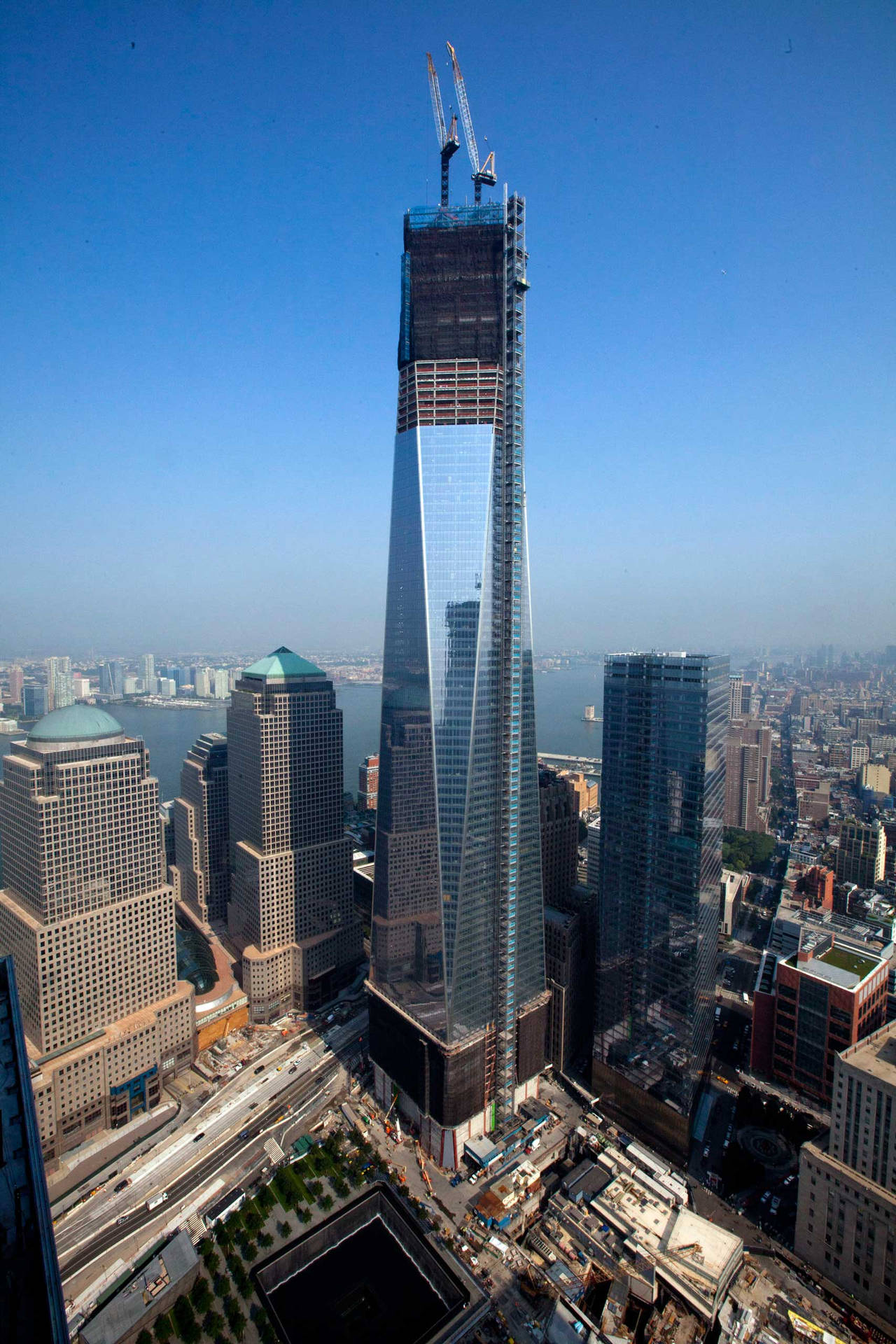 One World Trade Center With Cranes Background