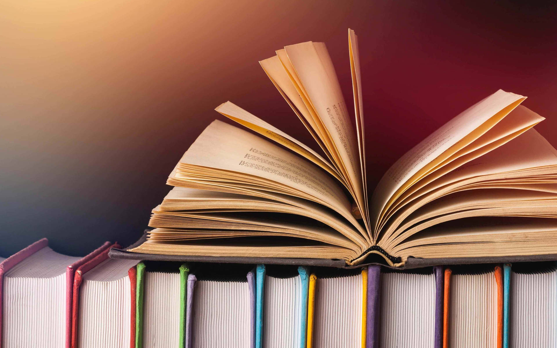 Opened Book Laying On Top Of A Stack Of Multicolored Books Background