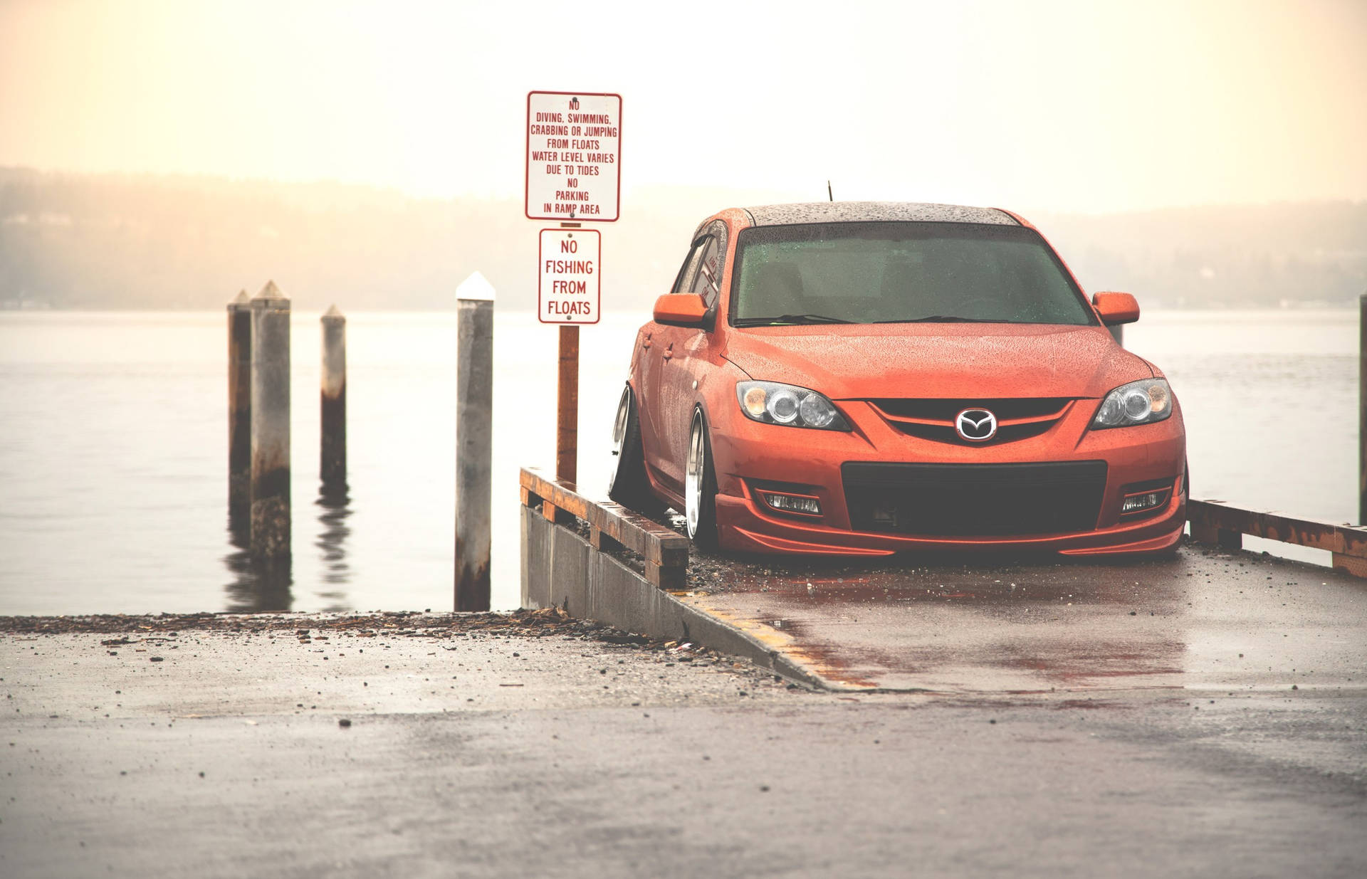 Orange Mazda 3 At Pier Background