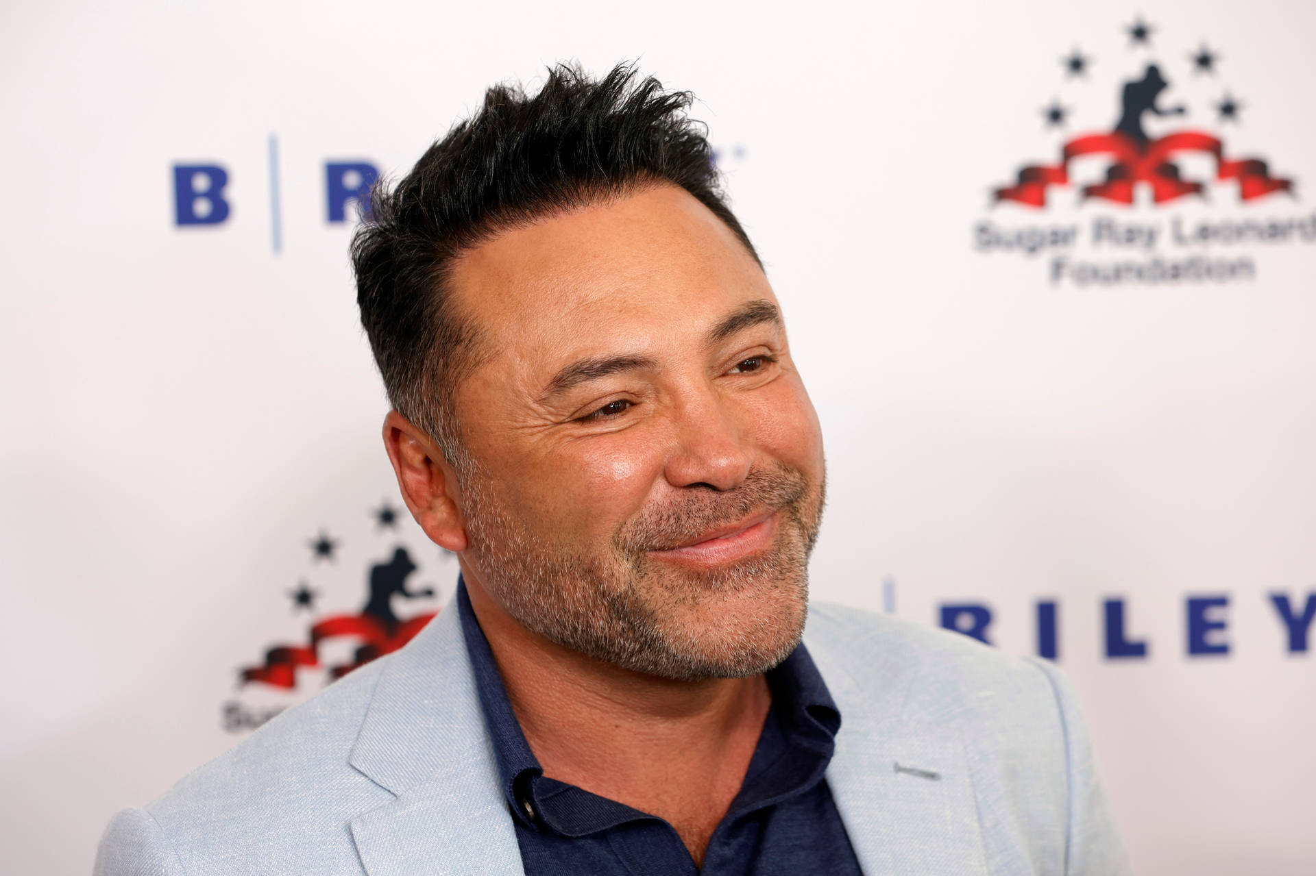 Oscar De La Hoya Happy In White Suit Background