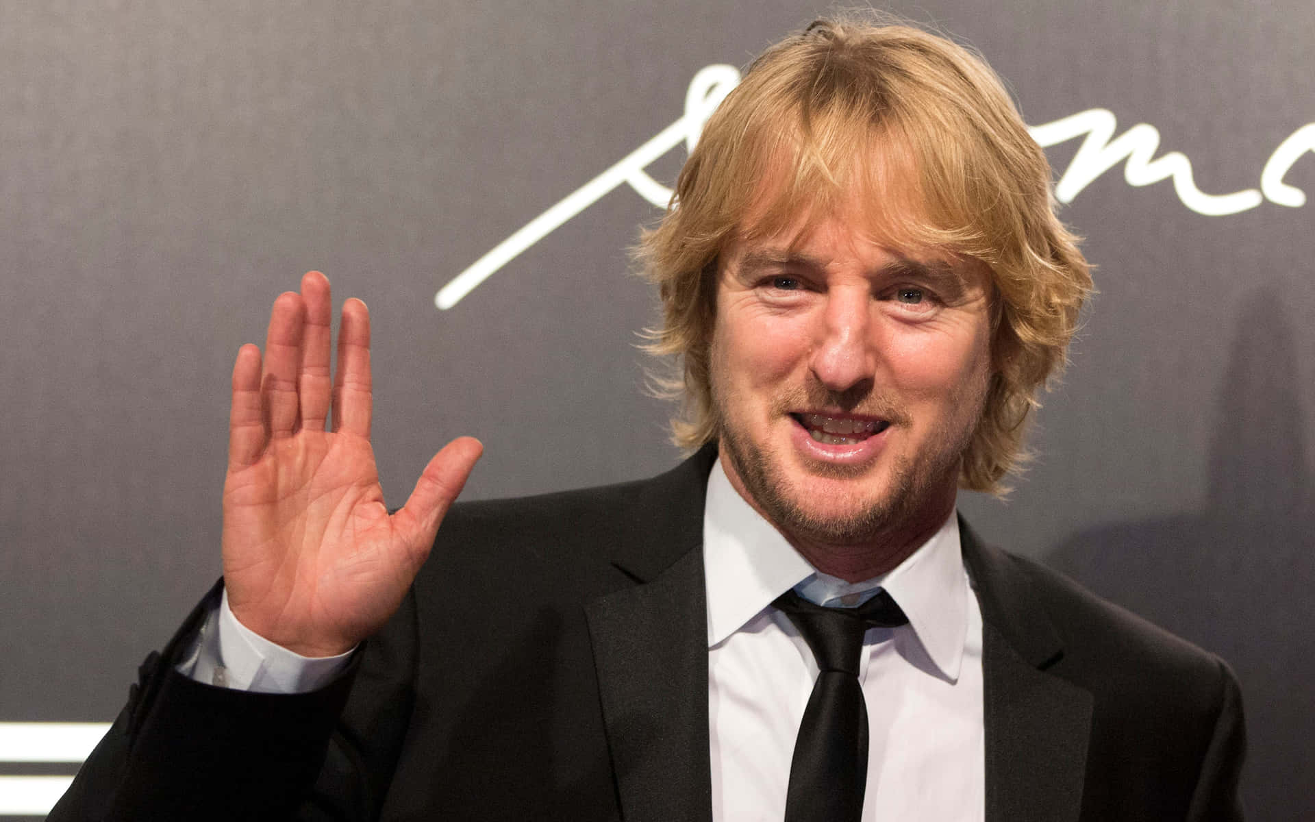 Owen Wilson Looking Dapper In A Navy Blue Suit Background