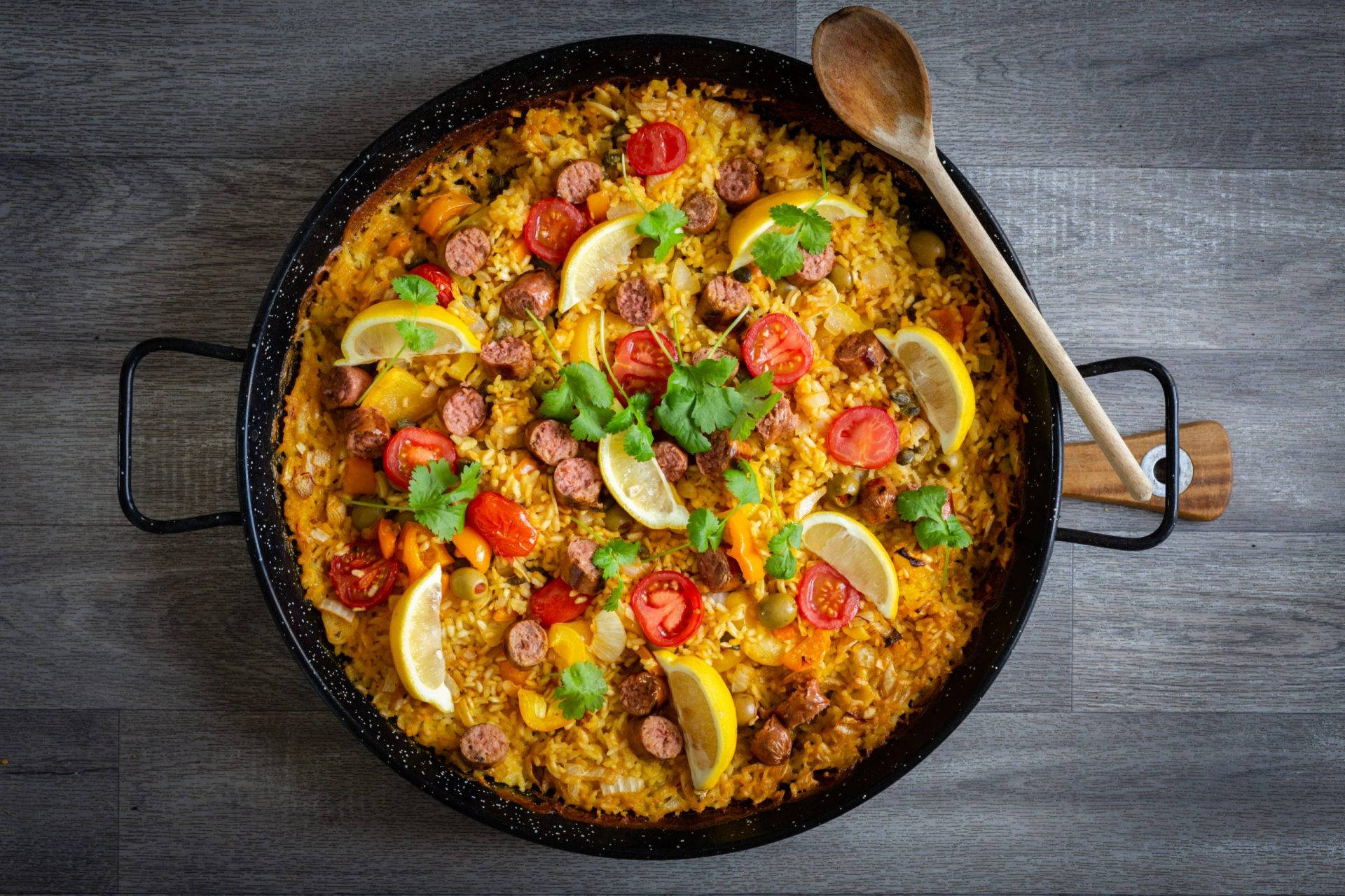 Paella Dish With Lemons And Sausages Background