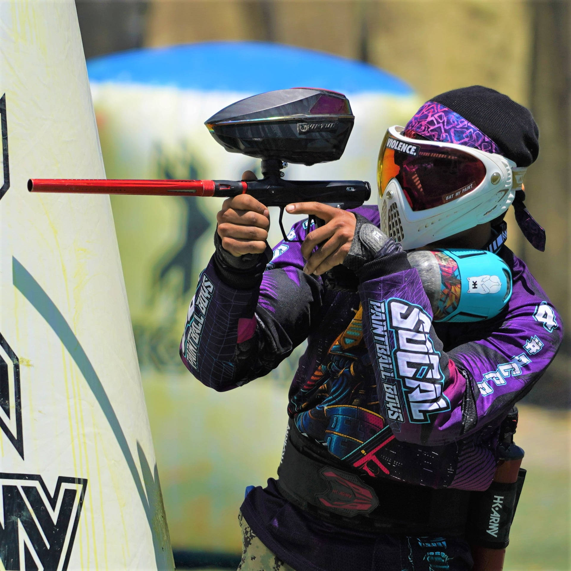 Paintball Player Aiming Behind A Bunker Background