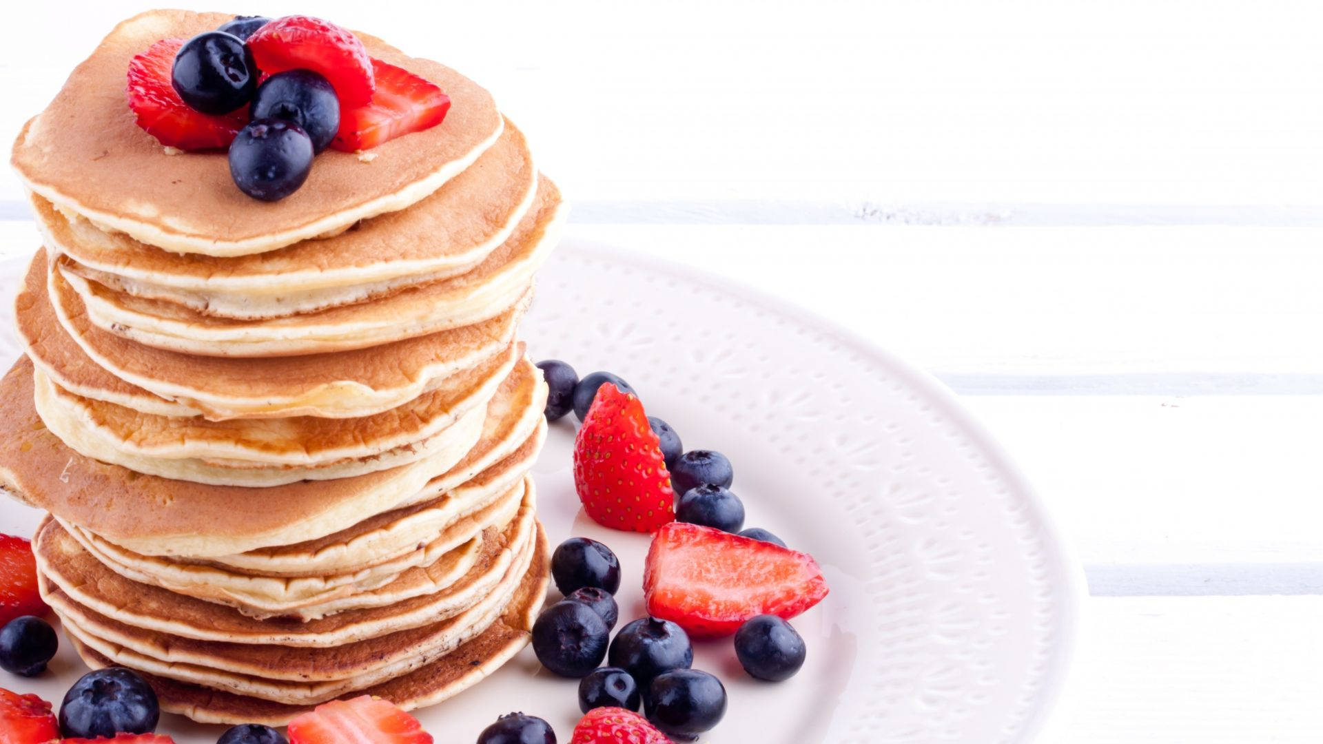 Pancakes Surrounded By Berries Background