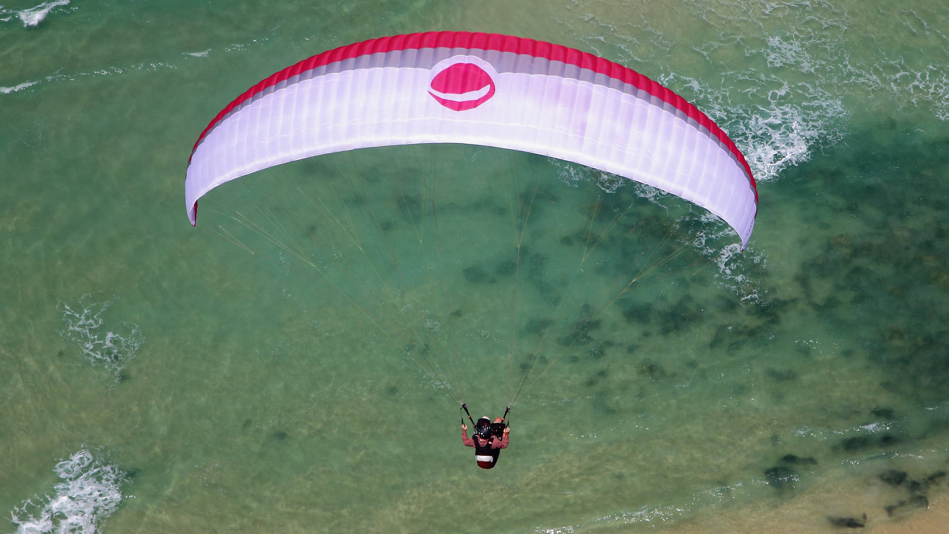 Paragliding Above Green Waters Background