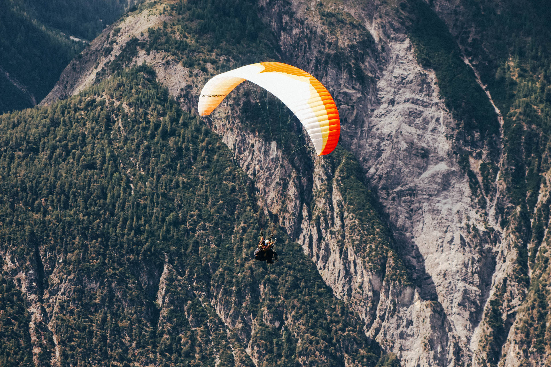 Paragliding Above Steep Mountain Background
