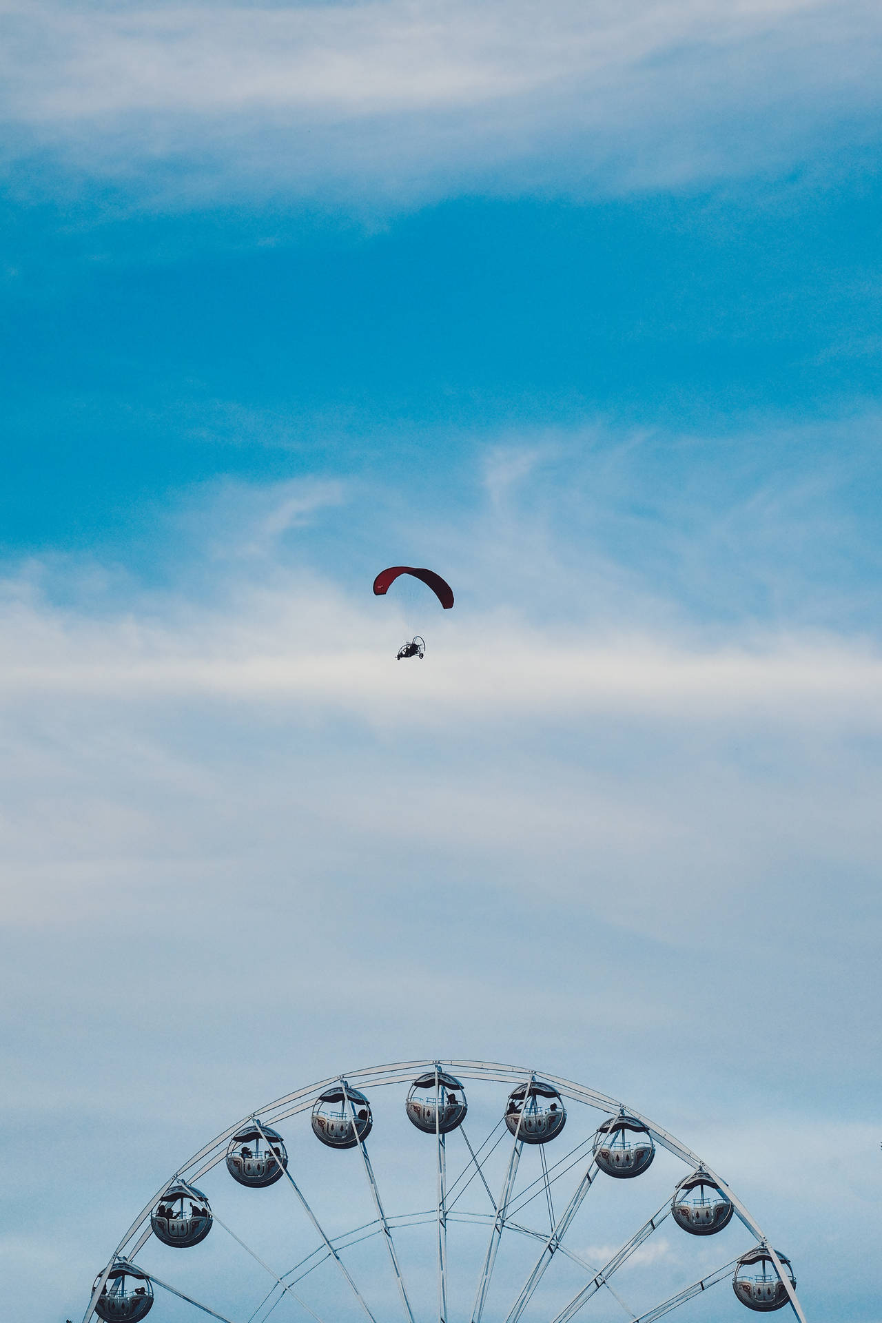 Paragliding Over Ferris Wheel Background