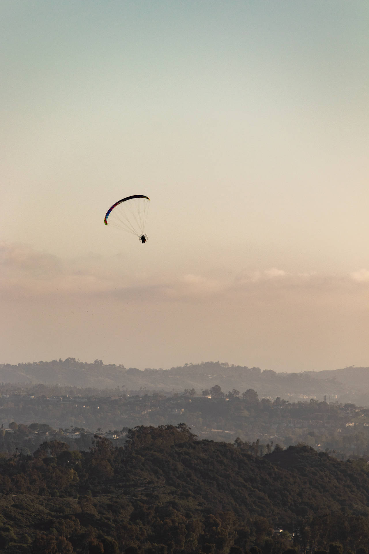 Paragliding Under Pastel Sky Background