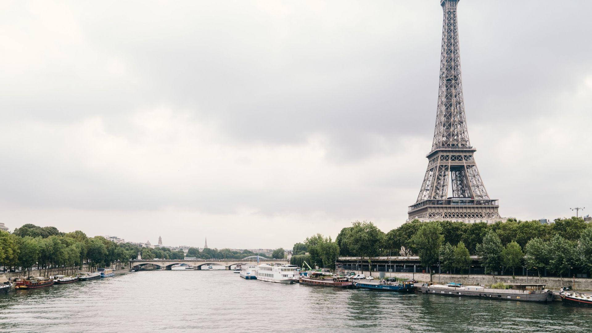 Paris Eiffel Tower Under A Cloudy Sky Background