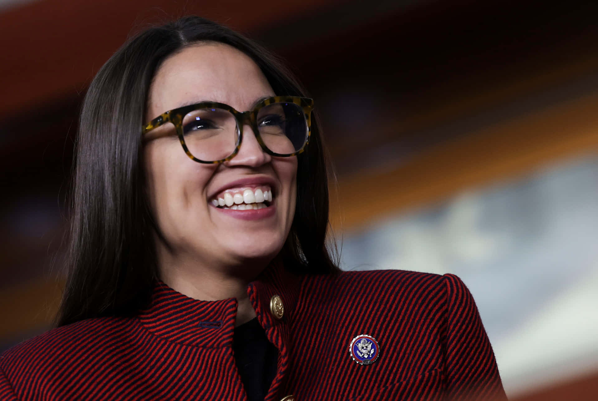Passionate Politician Alexandria Ocasio-cortez In Maroon Outfit Background