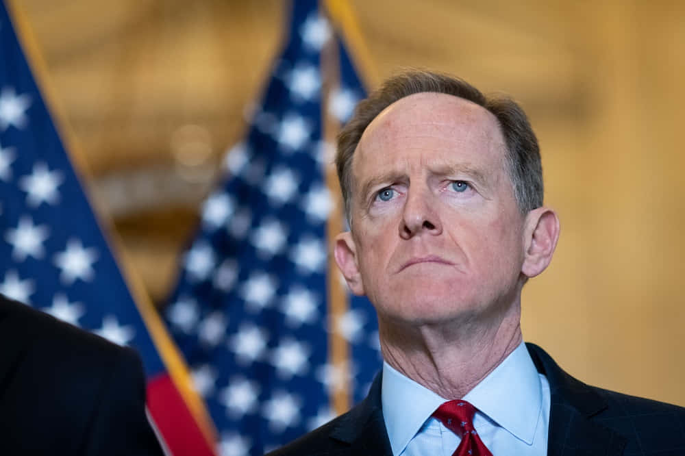 Pat Toomey In Front Of Flags Background