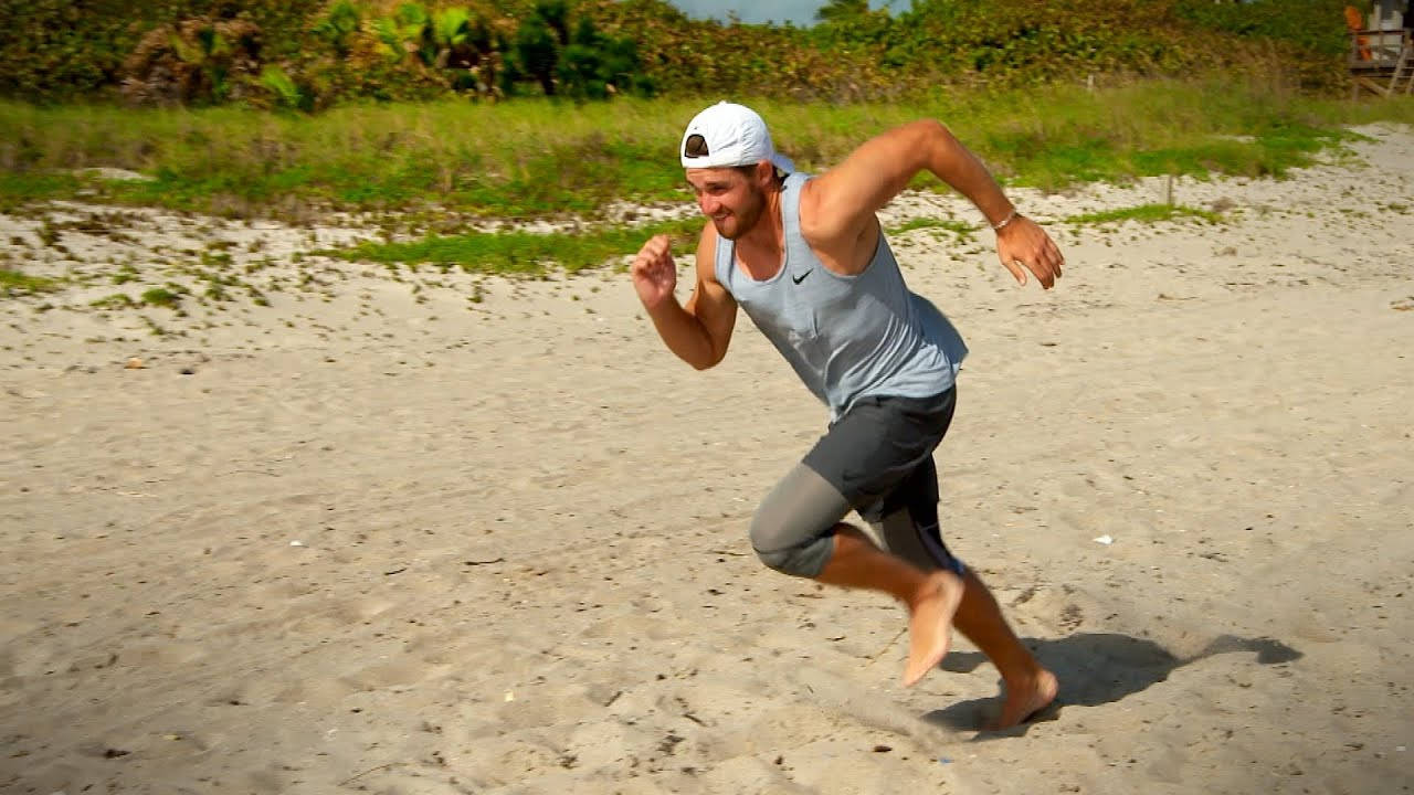 Patrick Rodgers Running On Beach Background