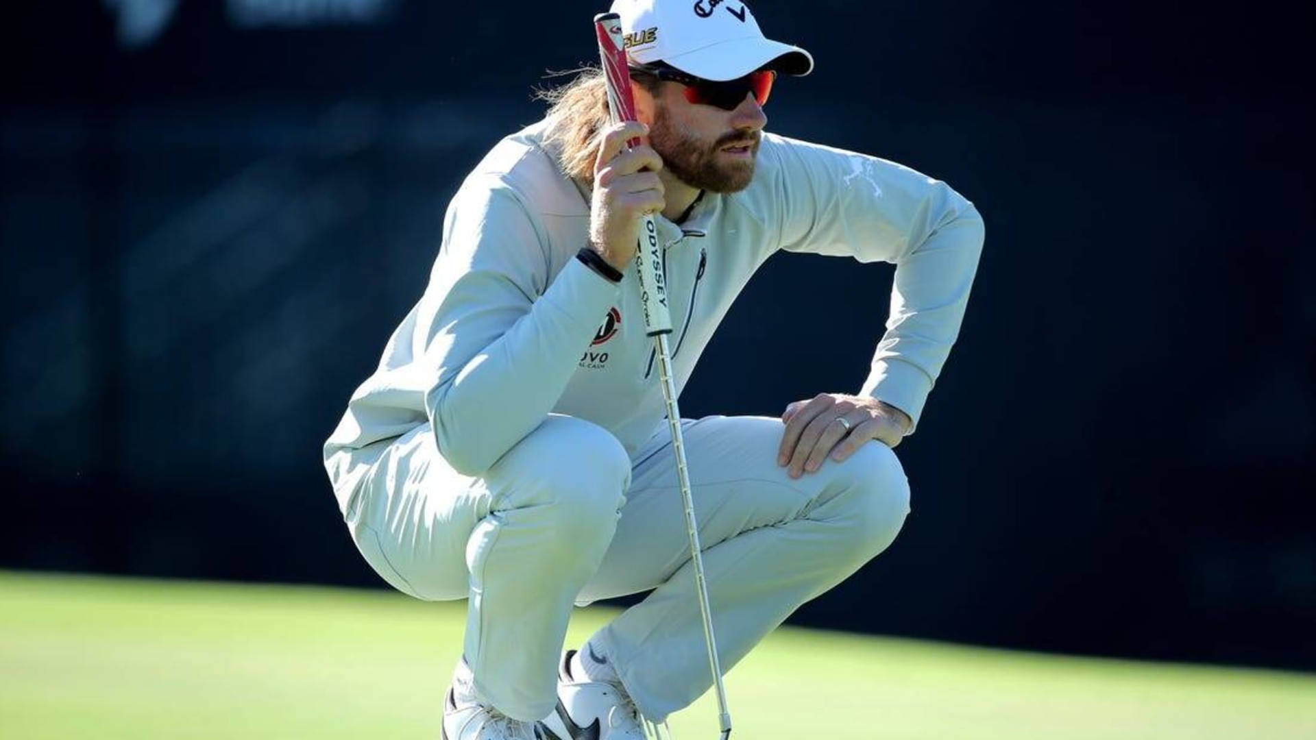 Patrick Rodgers Squatting In The Field Background