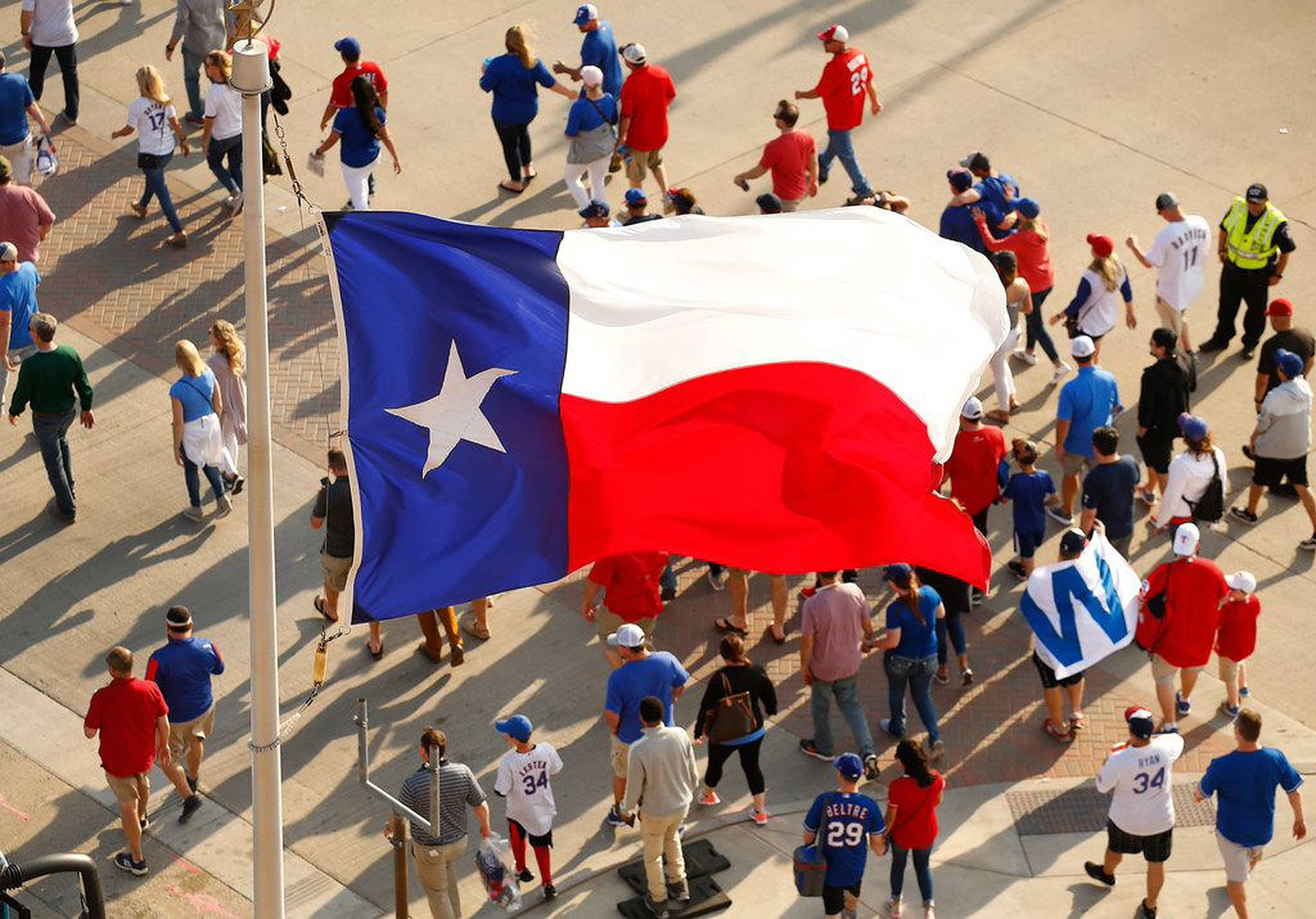 Patriotic Crowd In Front Of Texas Flag Background