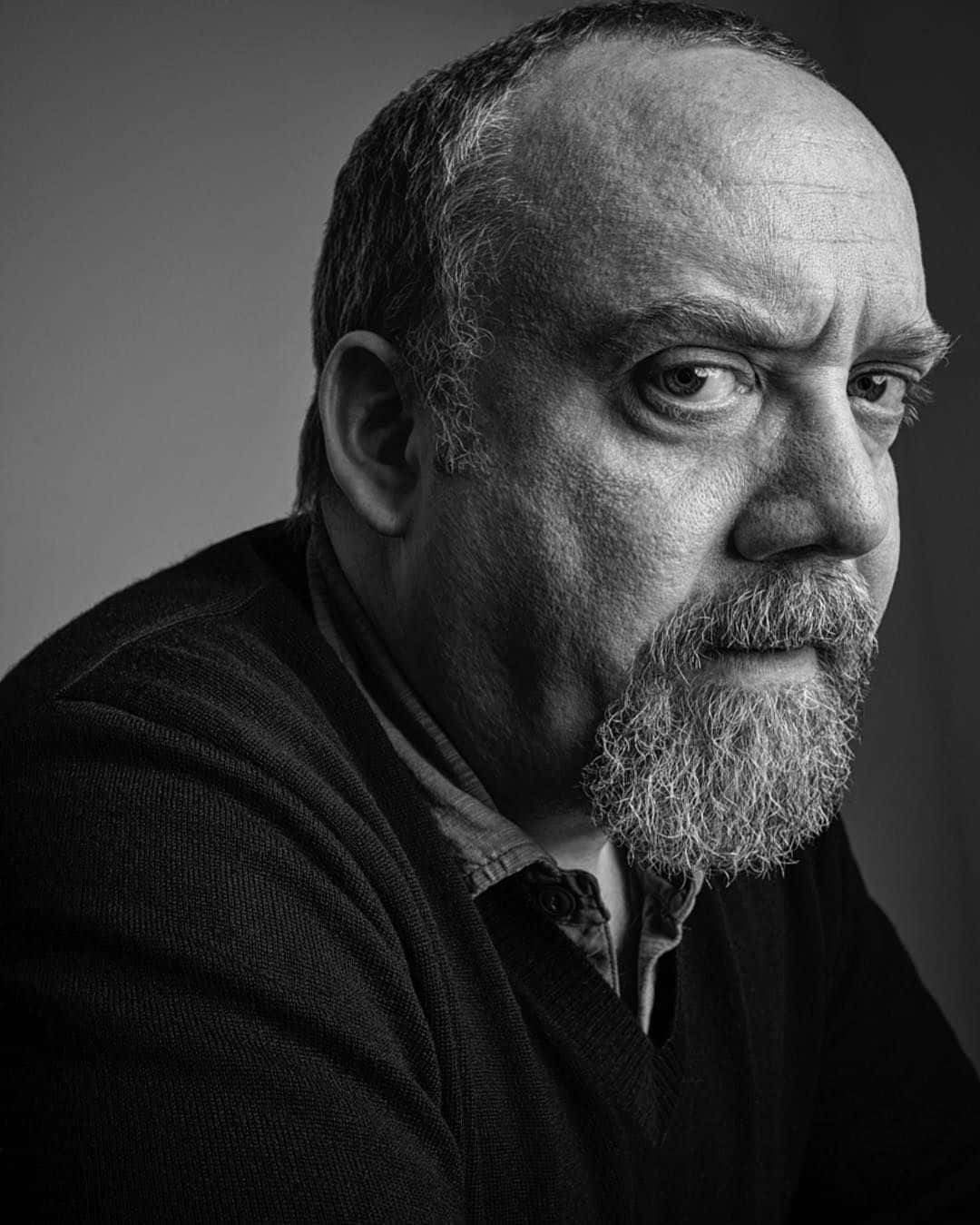 Paul Giamatti In A Black Suit And Blue Tie. Background