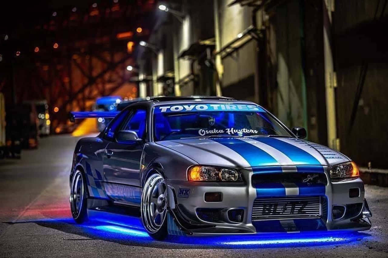 Paul Walker Behind The Wheel Of A Nissan Skyline Background