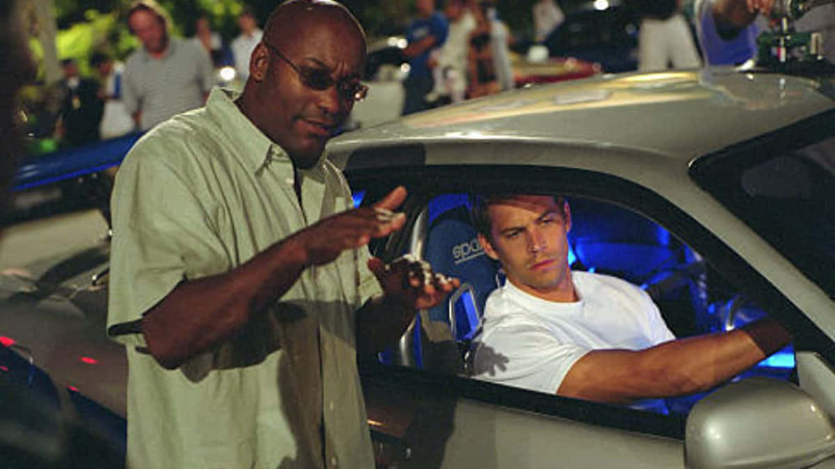 Paul Walker Behind The Wheel Of A Nissan Skyline Background