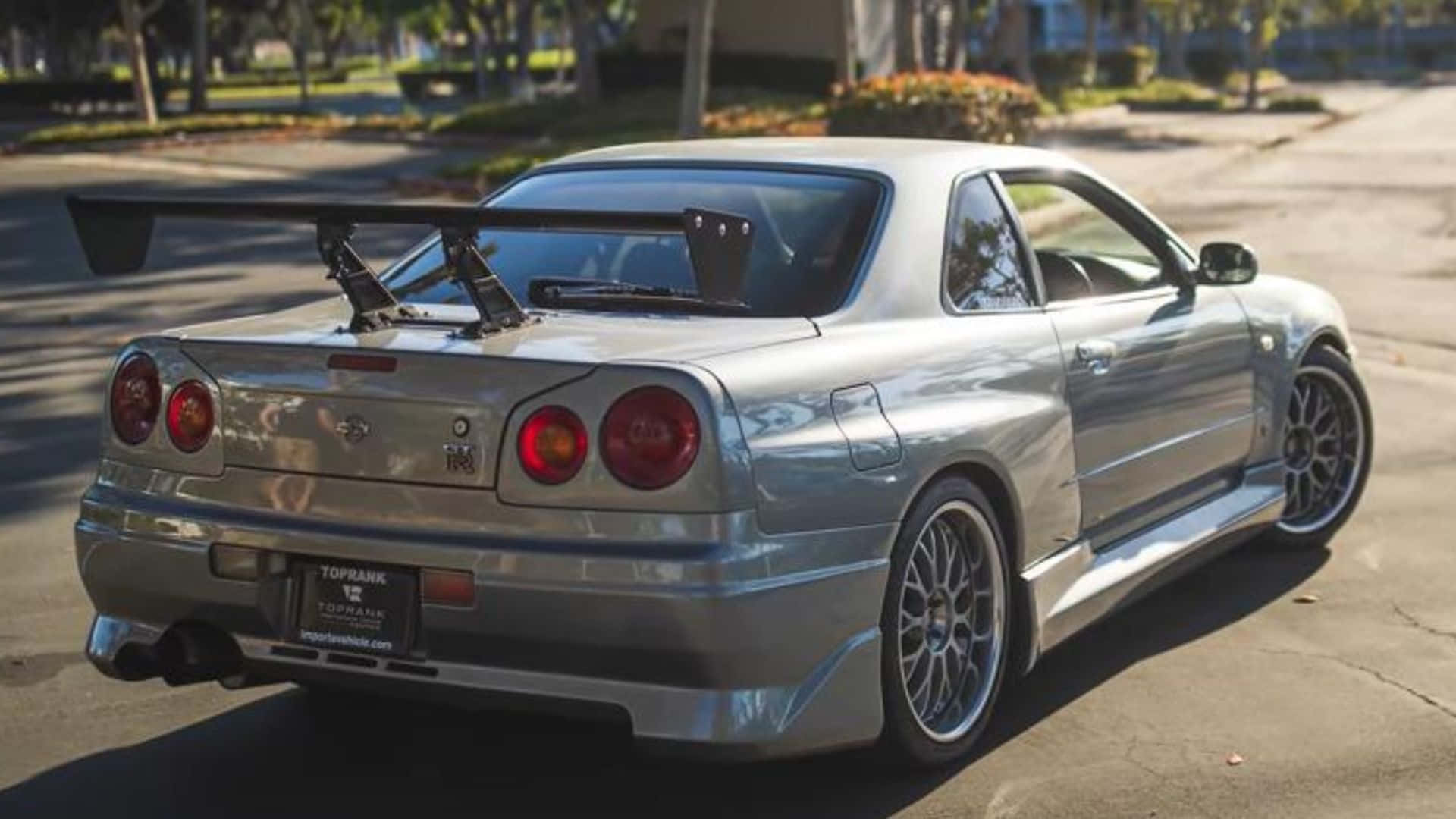 Paul Walker Tearing Up The Asphalt In A Nissan Skyline Background