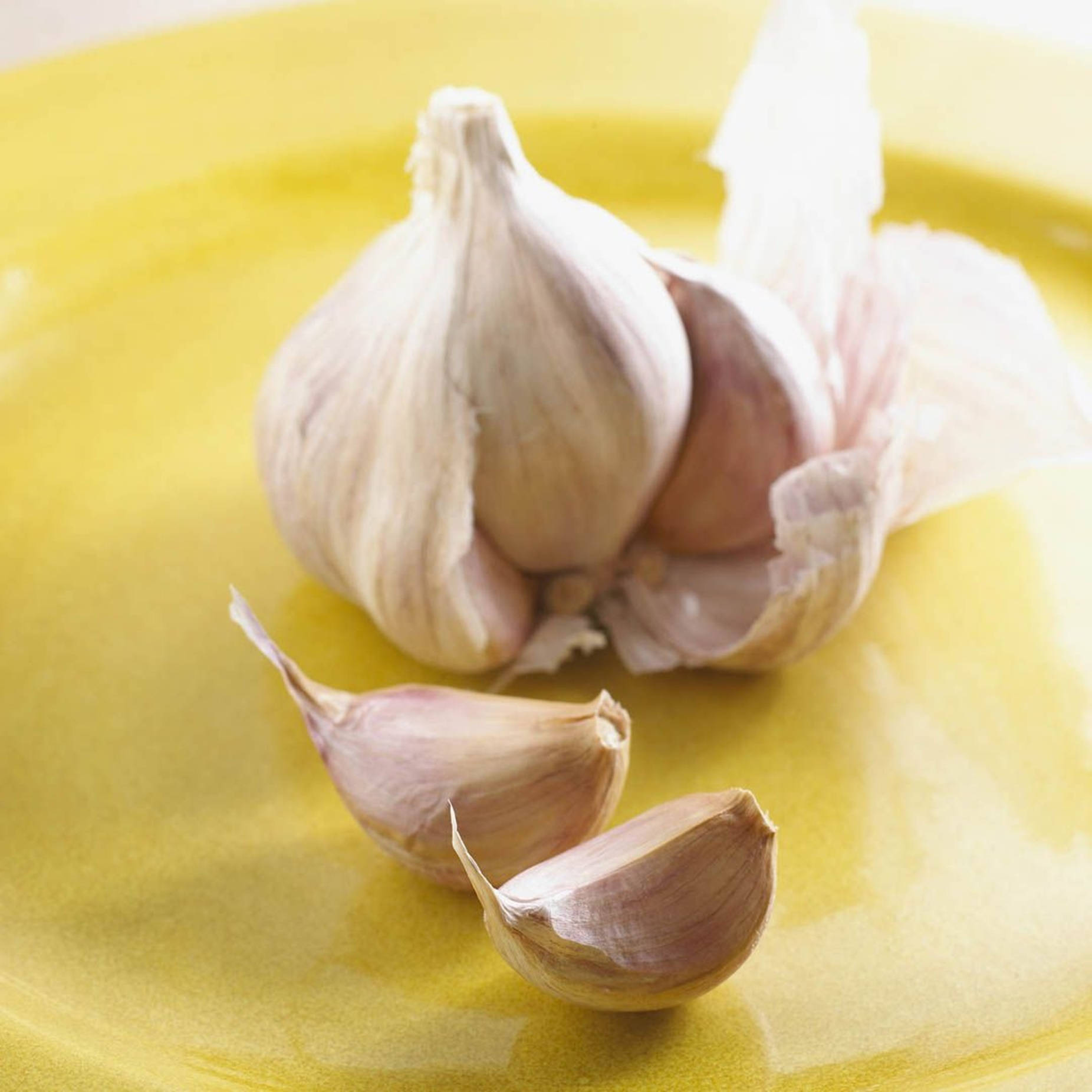 Peeled Garlic Vegetable Herb On Yellow Plate Background