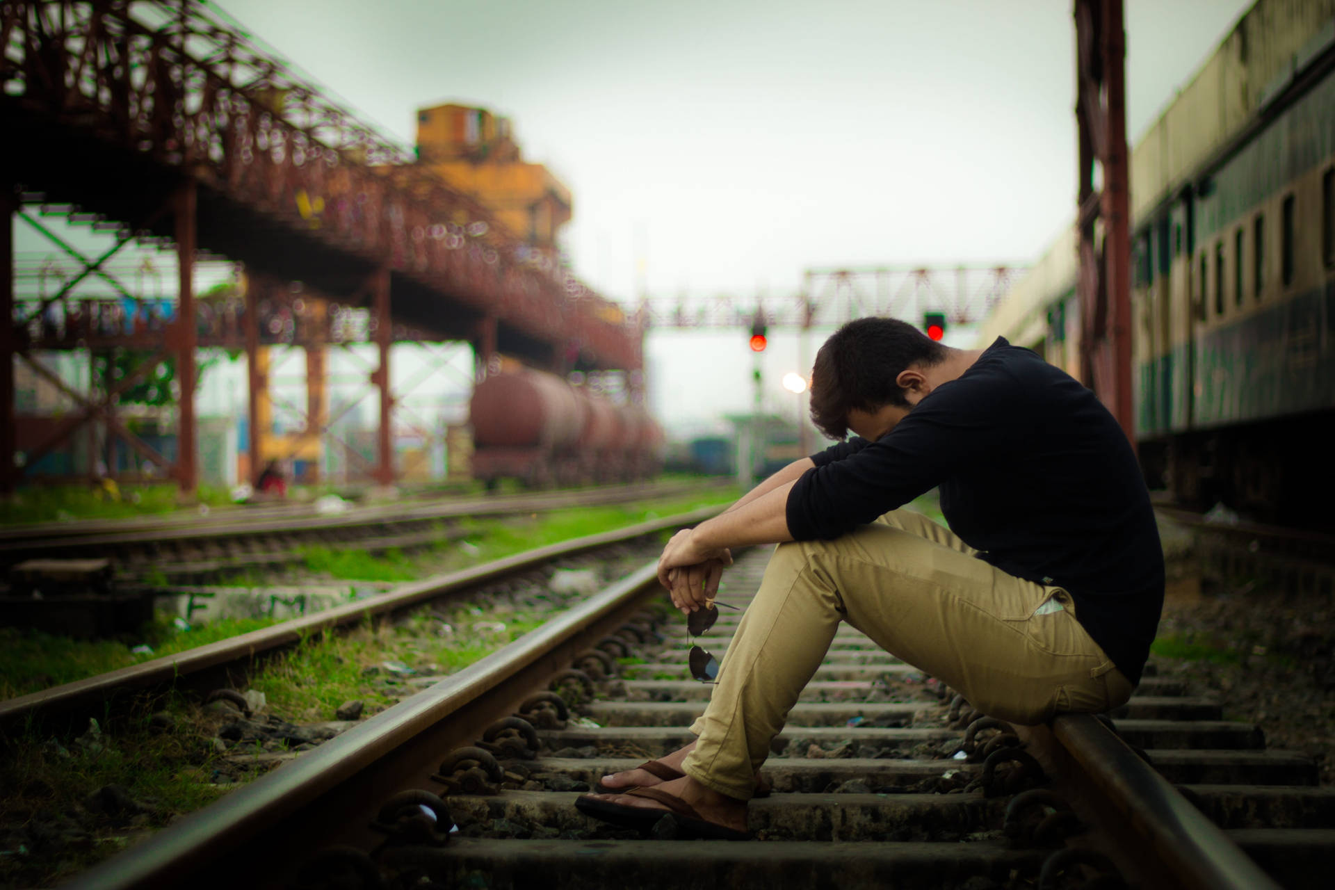 Pensive Sad Boi Pondering On Train Tracks Background