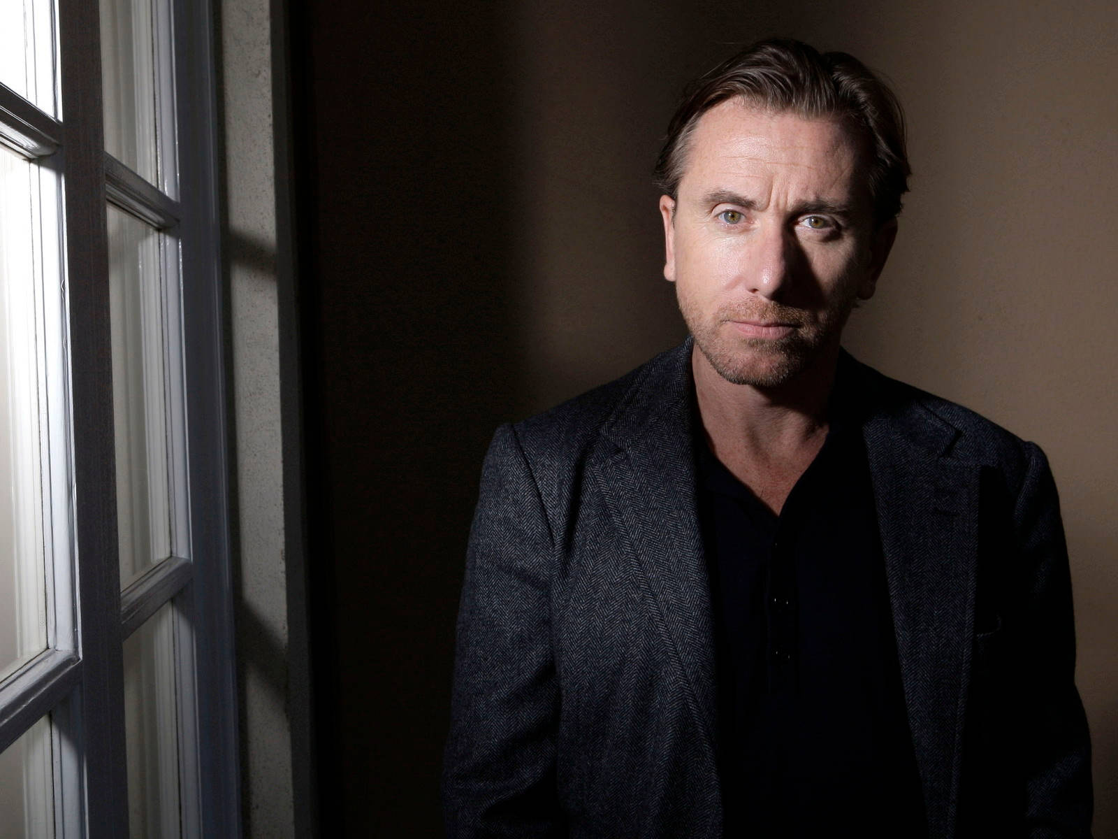 Pensive Tim Roth In Black Attire Background