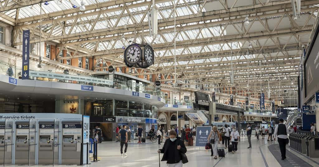 People At Waterloo Station With Clock Background