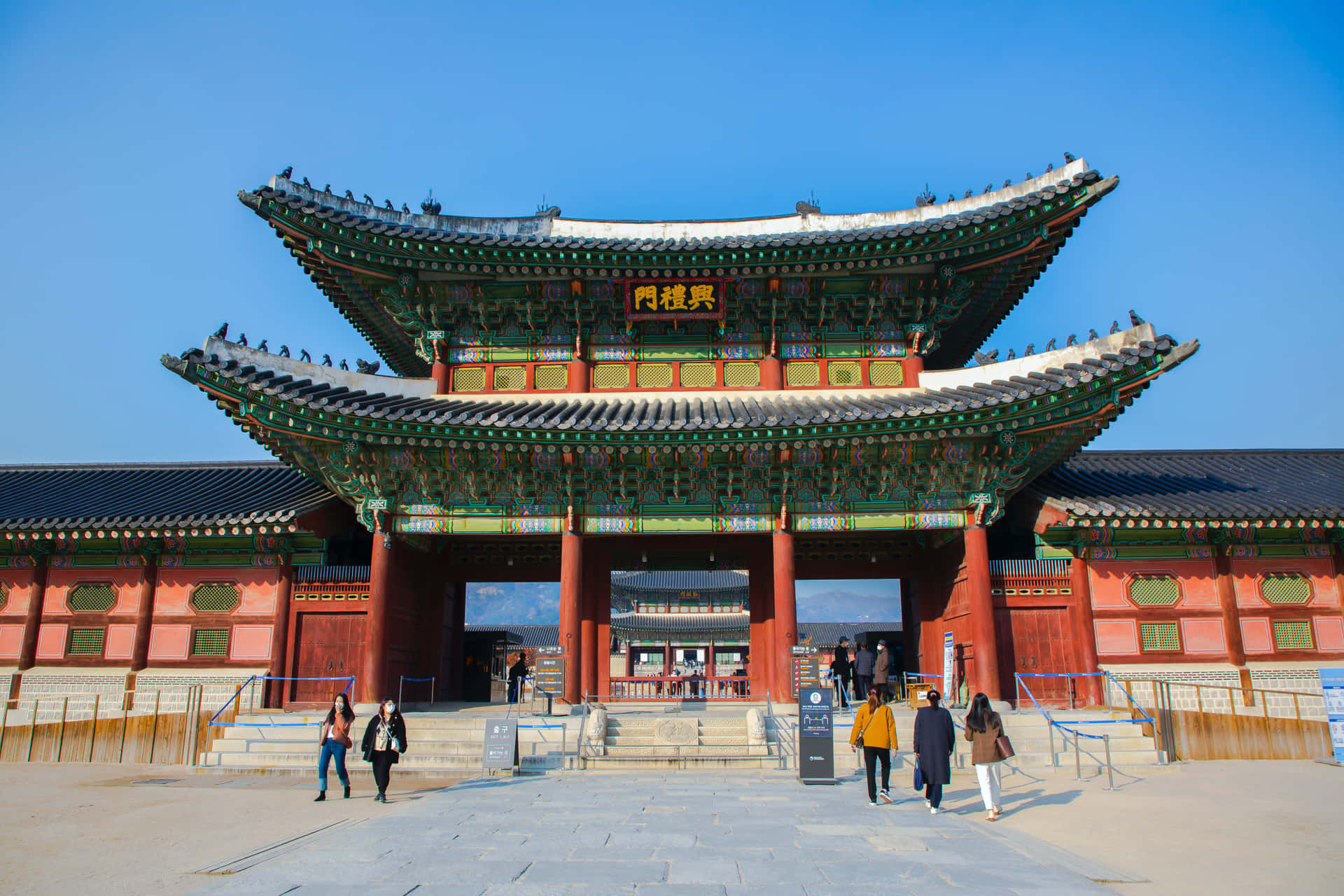 People Entering And Exiting Gyeongbokgung Palace Background