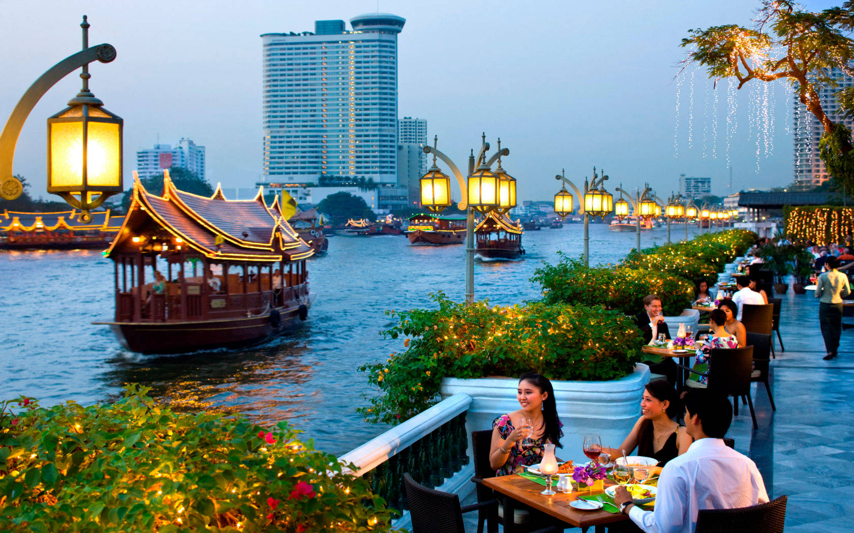 People Having Dinner Along The Riverside Background