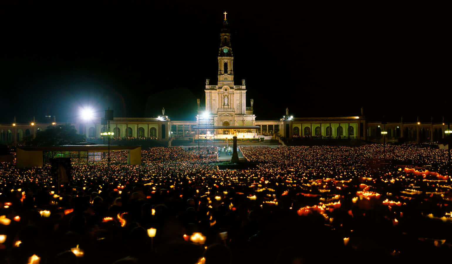 People Holding Lights Outside Fatima Sanctuary Background