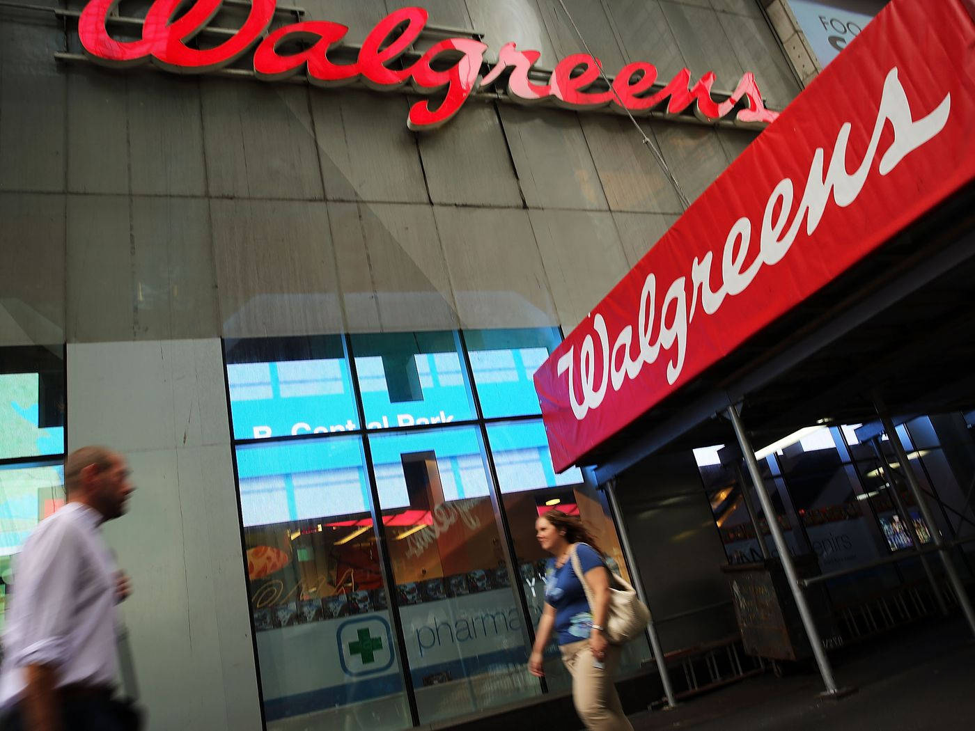 People Passing Walgreens Store