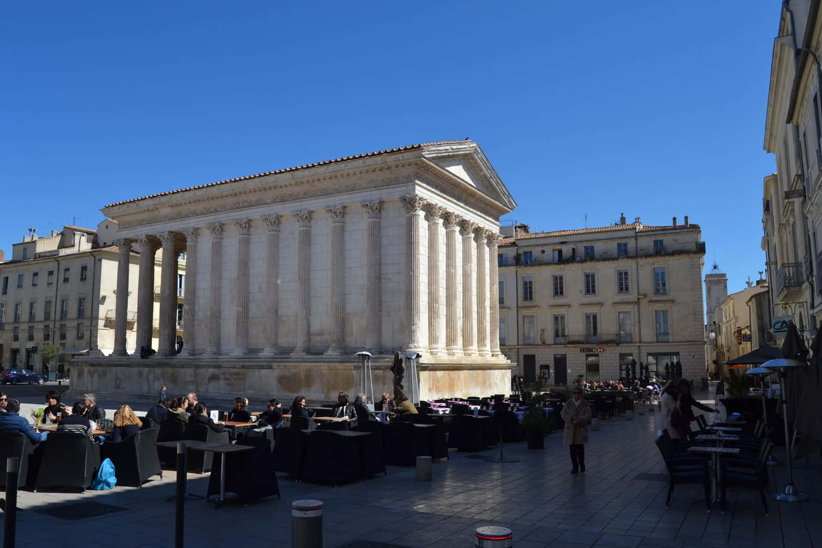 People Seated Behind Maison Carrée Background