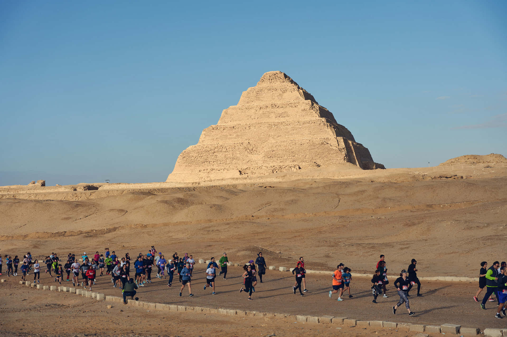 People Walking Around Saqqara Pyramid Background