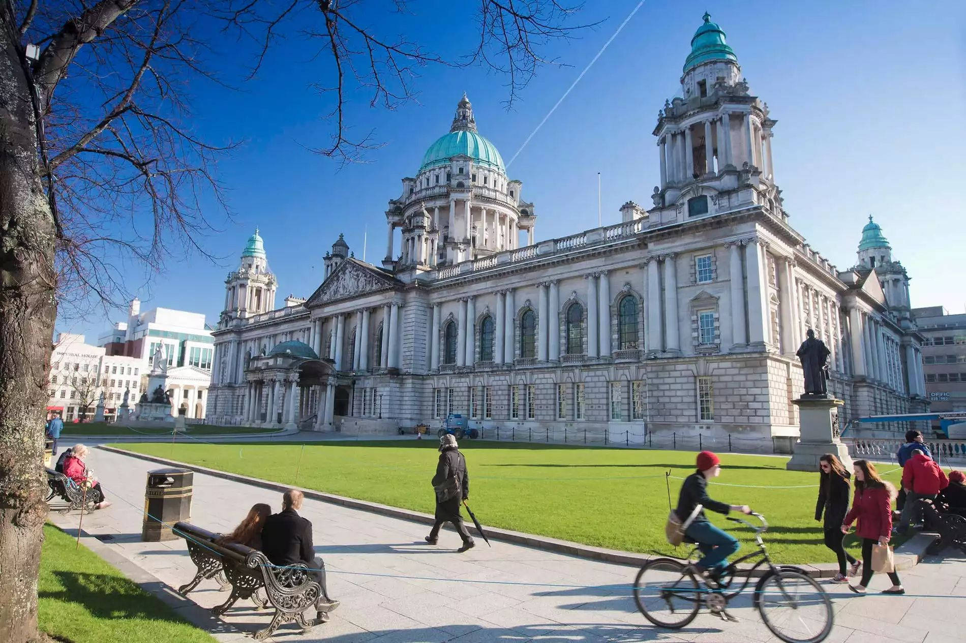 People Walking In Front Of A Large Building Background