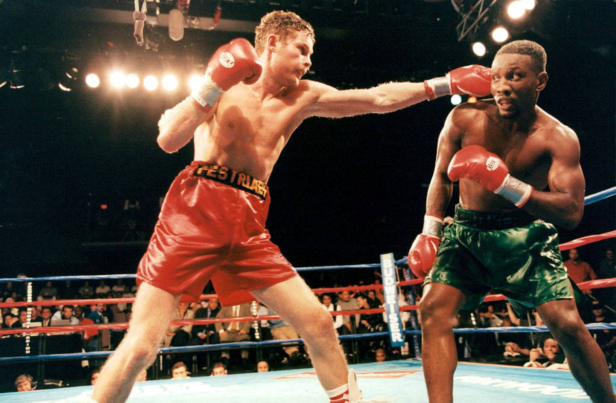 Pernell Whitaker Skillfully Evades An Opponent During A Boxing Match. Background