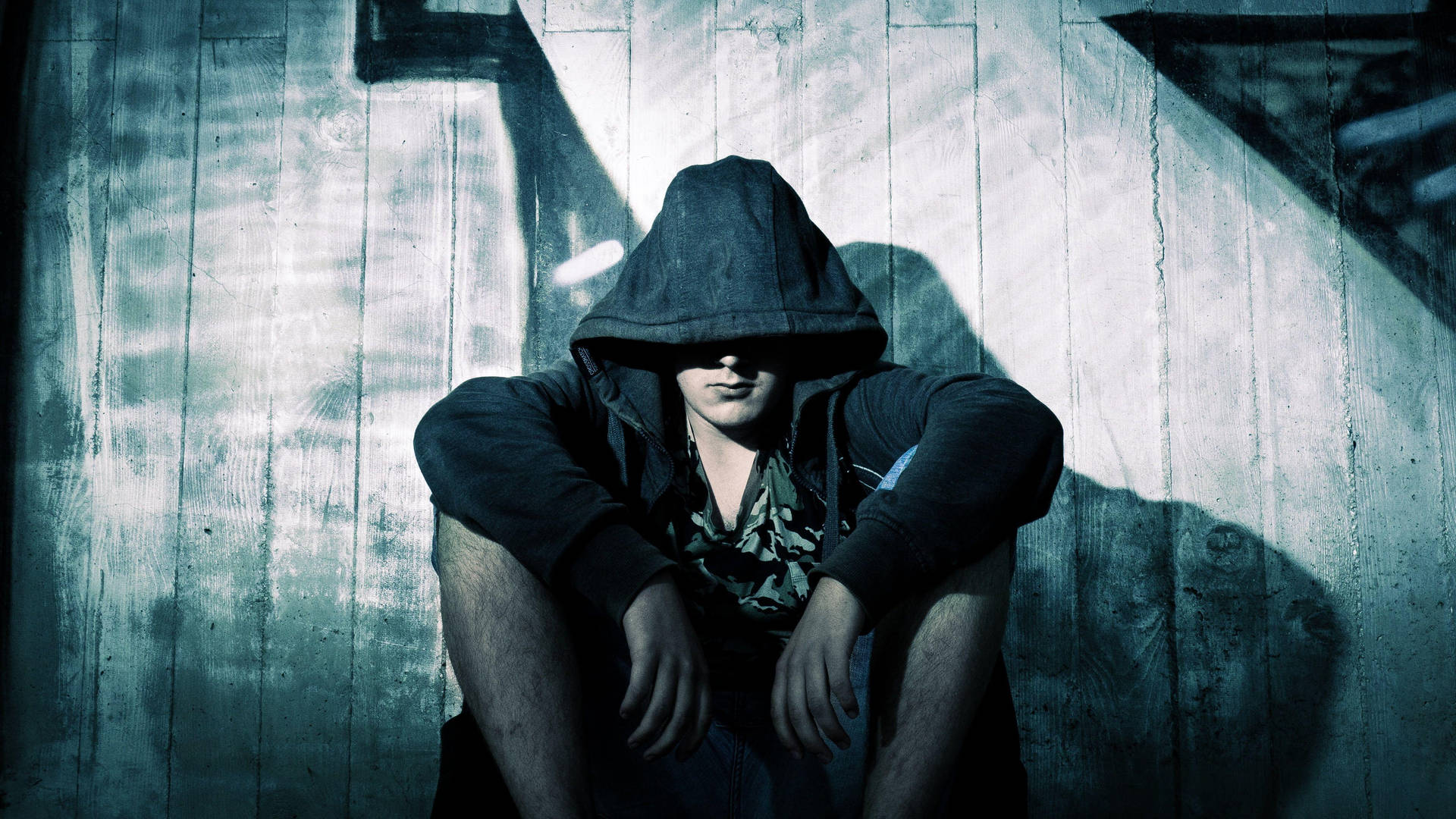 Person In Hoodie Leaning Against Wall