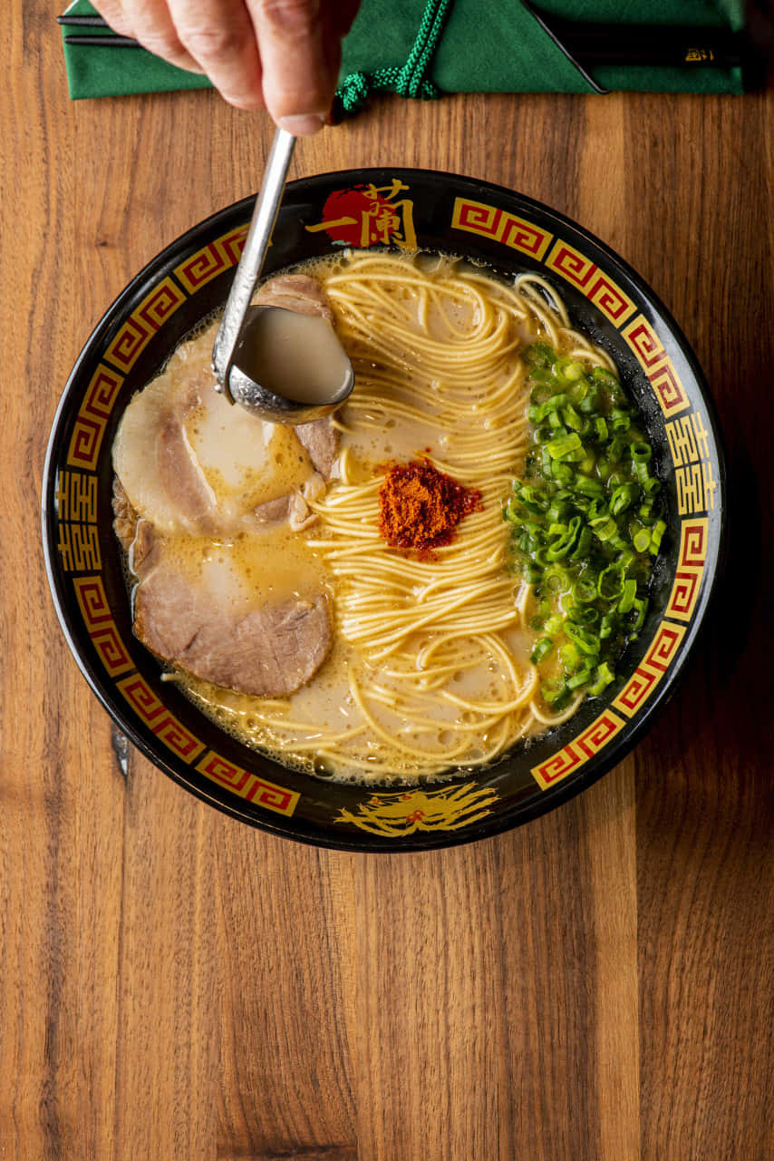 Person's Hand Scooping Ramen Background