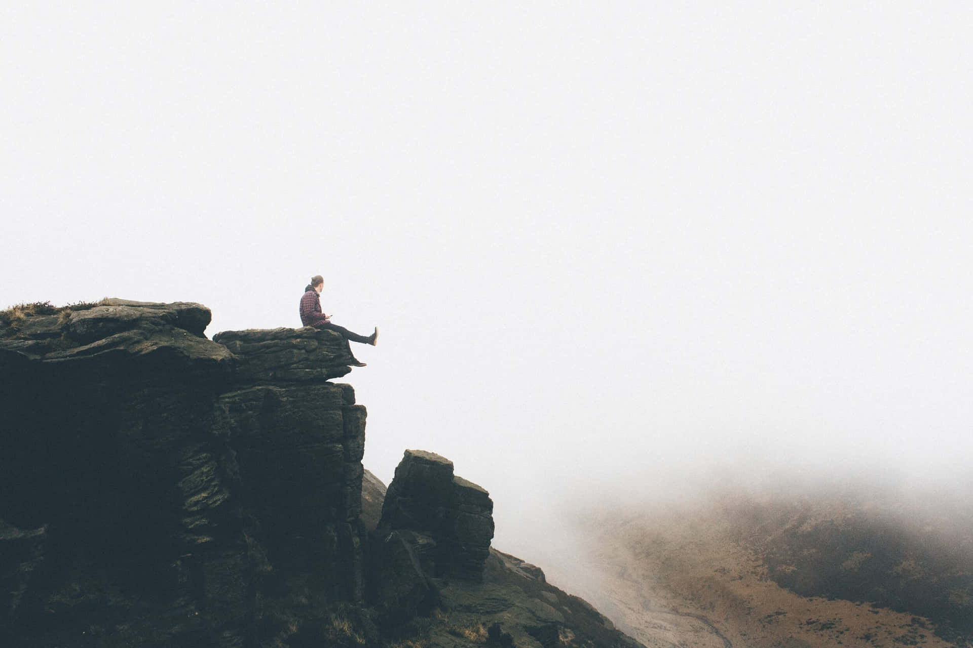 Person Sitting Along On Cliff Ledge