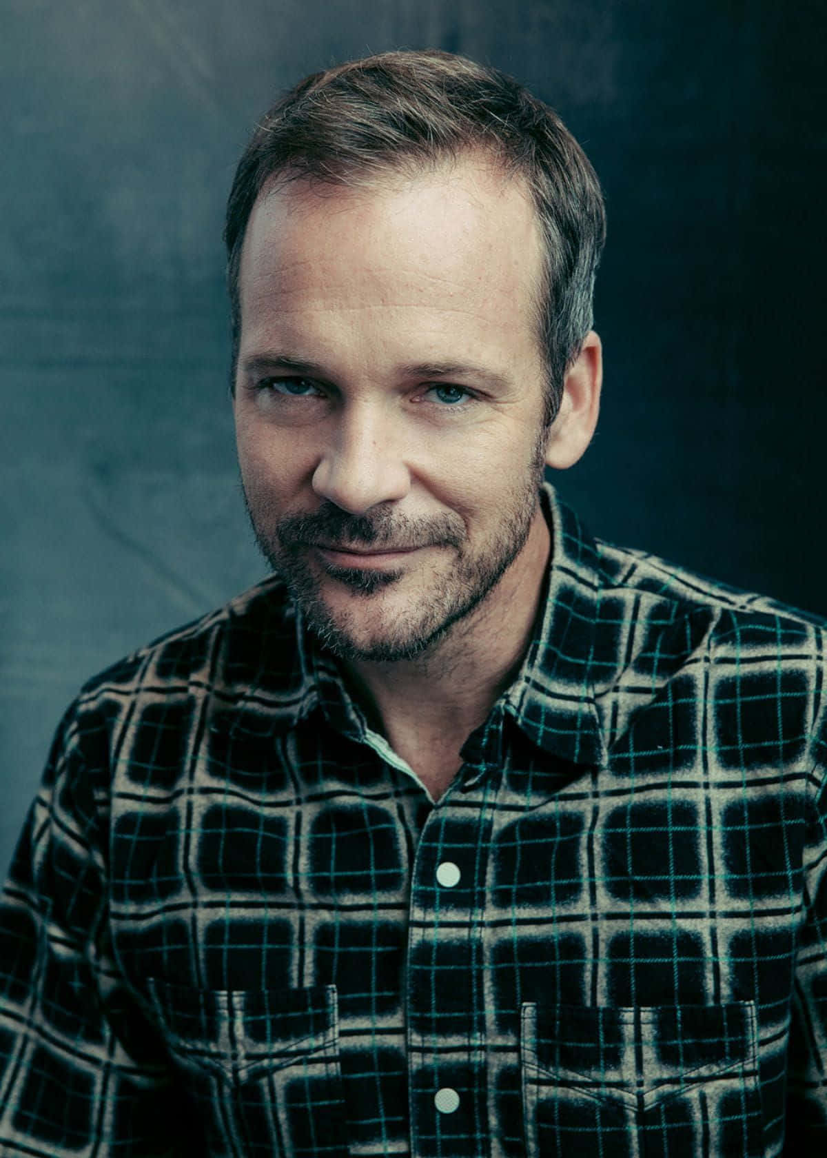 Peter Sarsgaard Staring Into The Camera. Background