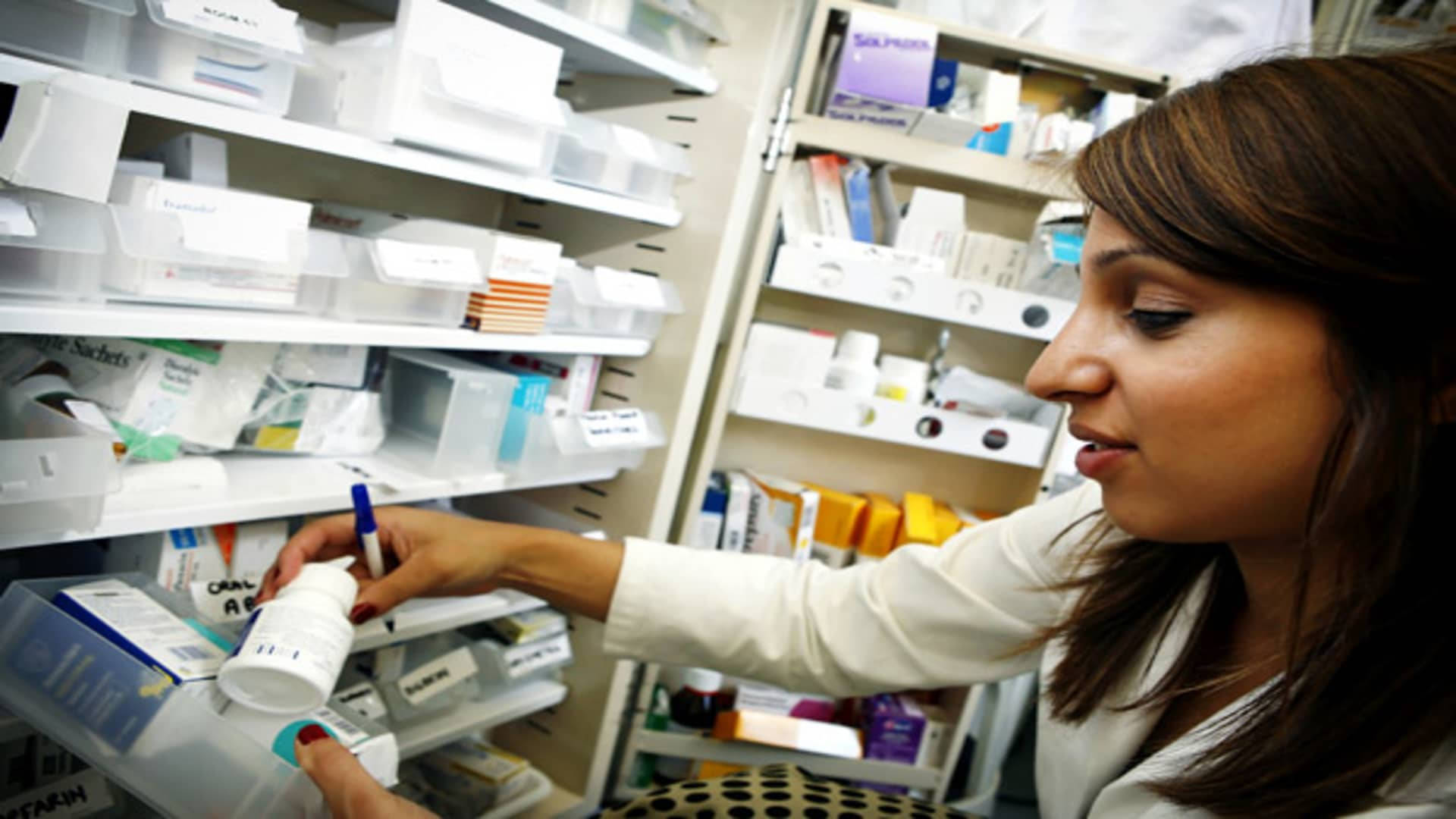 Pharmacist Checking A Medicine Bottle Background