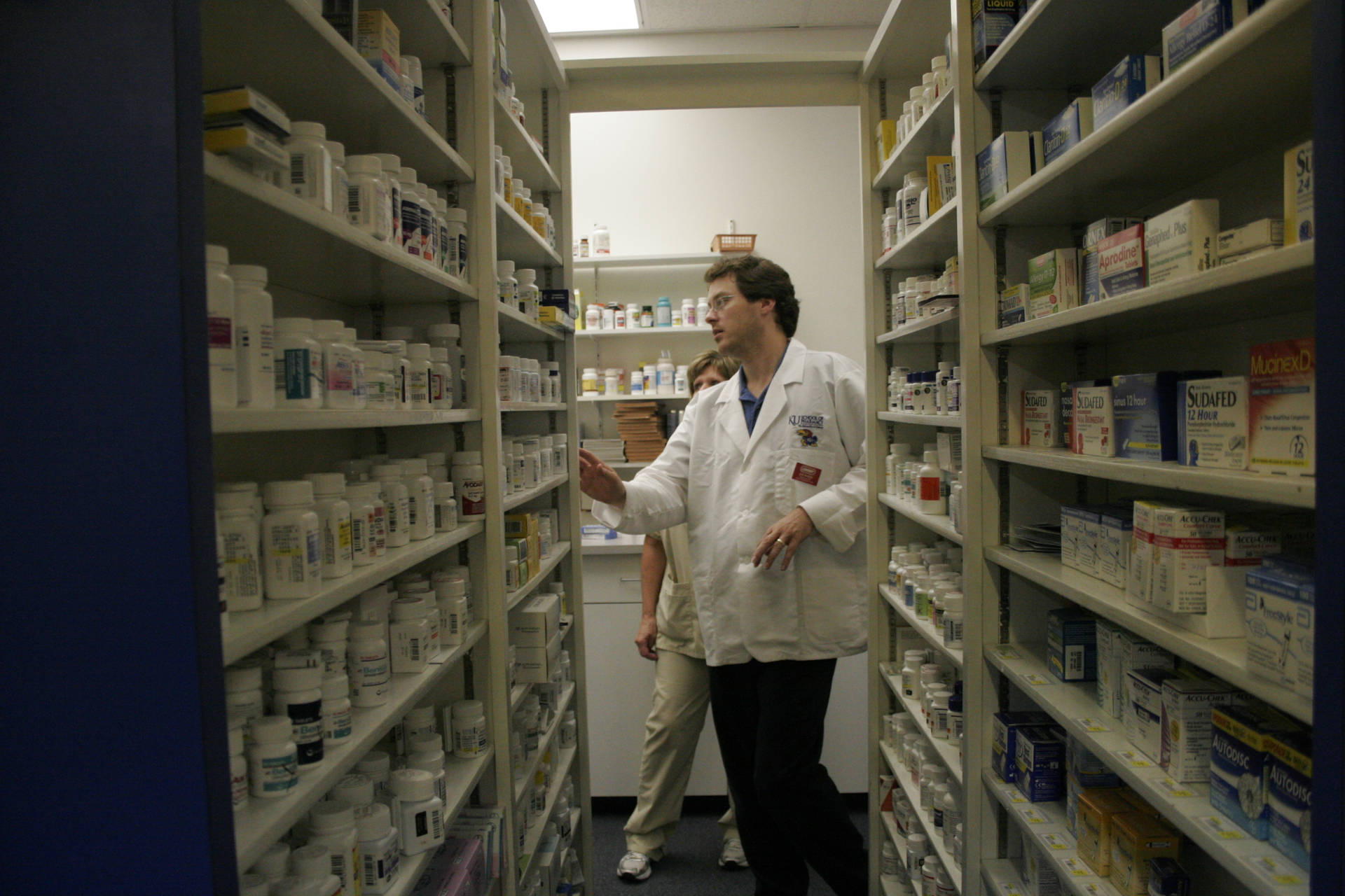 Pharmacist Looking Over Medicines Background
