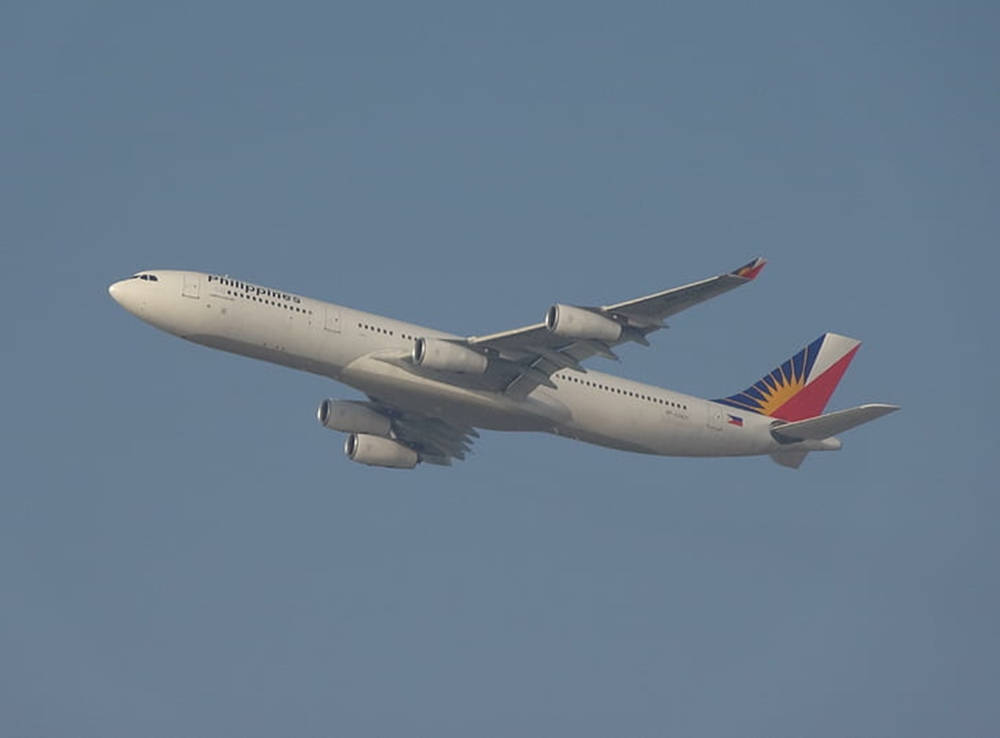 Philippine Airlines Airplane In Gloomy Skies Background