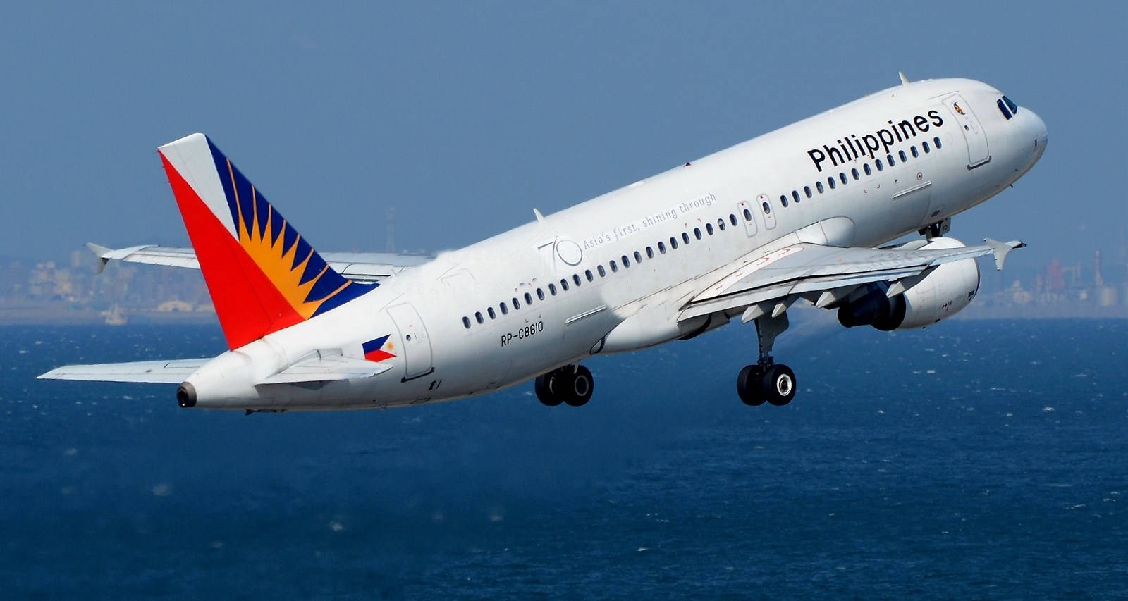 Philippine Airlines Flying Above The Sea Background