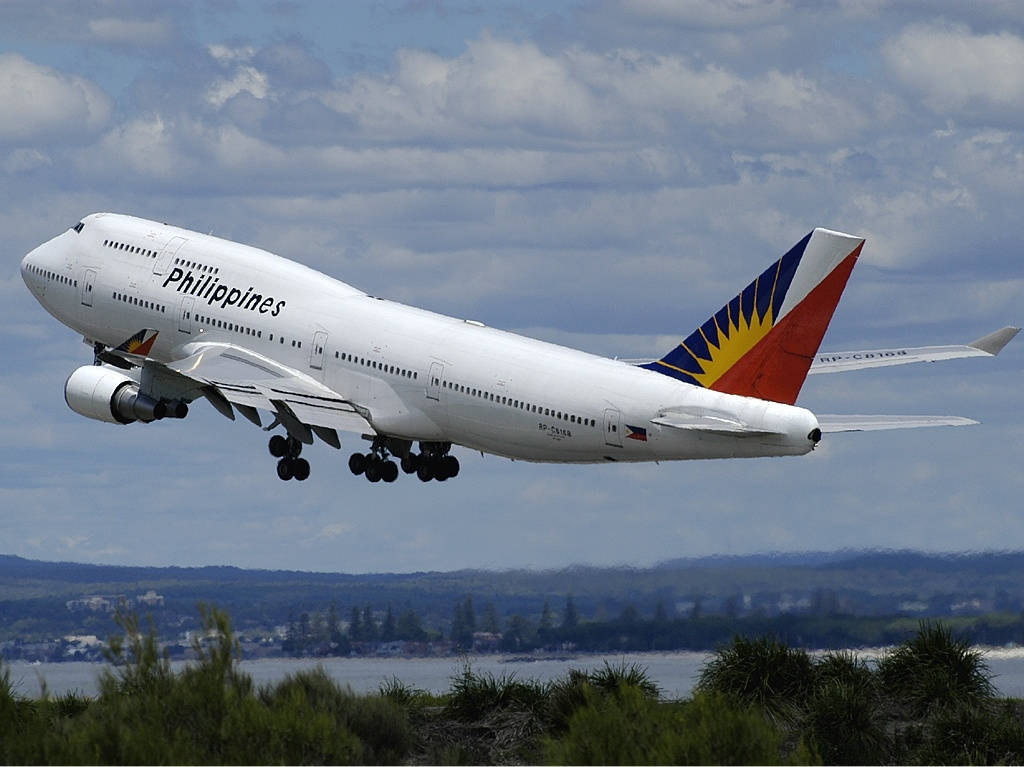 Philippine Airlines Plane Flying Above Trees Background