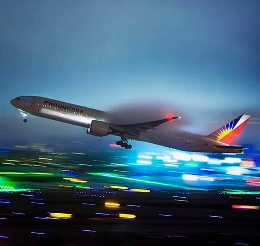 Philippine Airlines Takeoff Blurred City Lights Background