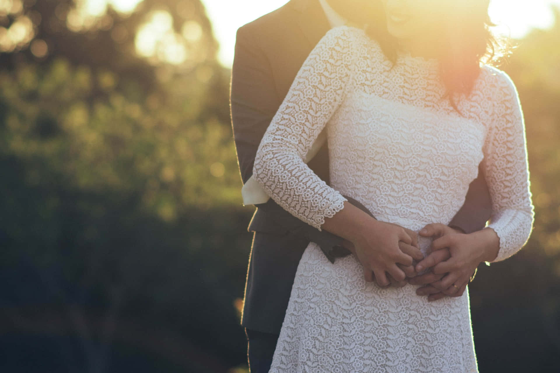 Photo Of A Couple's Tangible Hug Wearing White Dress And Black Suit Background